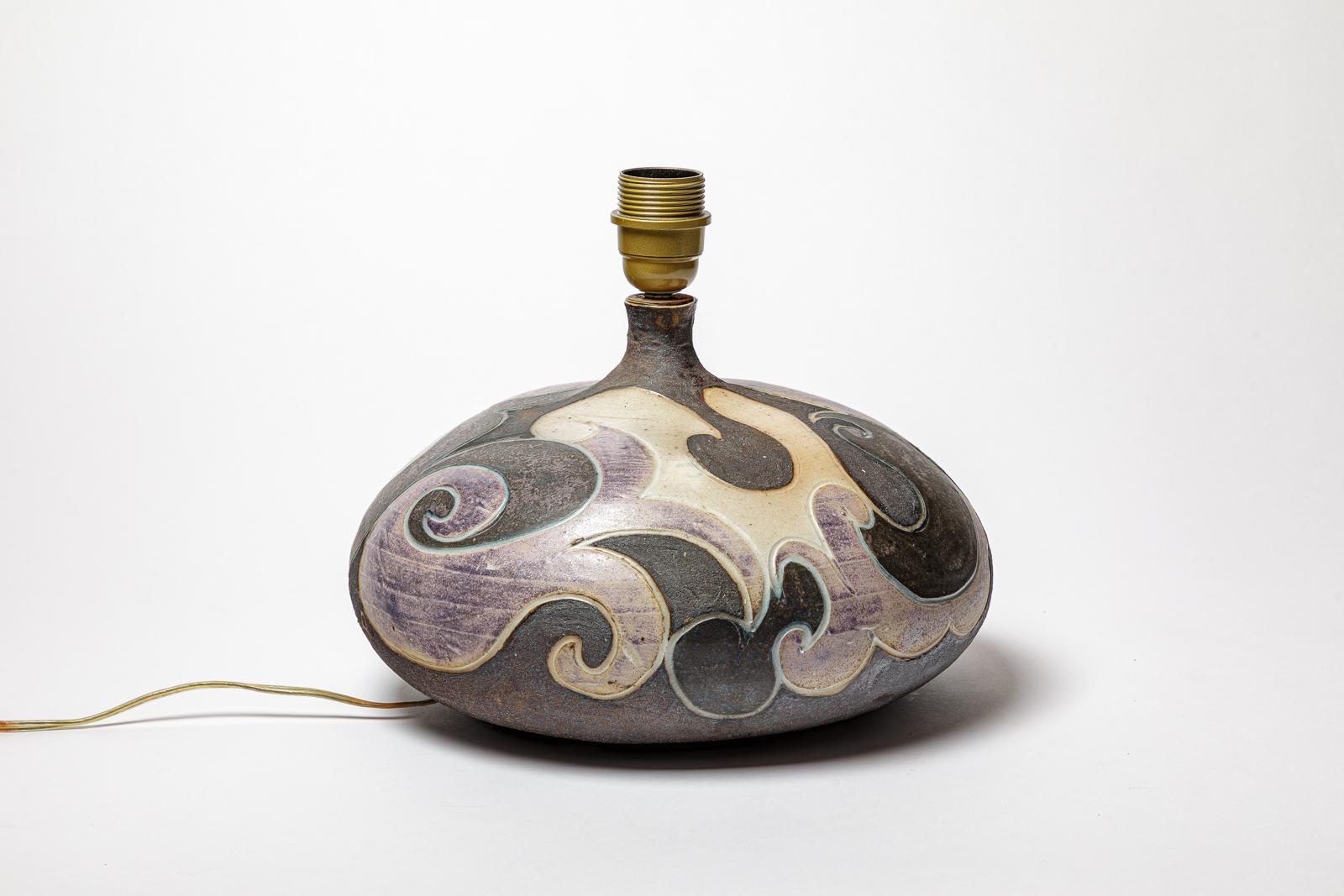 Lampe en grès à décor géométrique par Georges Martin.
Monogramme de l'Artistics sur la base. Circa 1970-1980.
H : 6.7 x 11 pouces (céramique uniquement).
Vendu avec un système électrique européen.