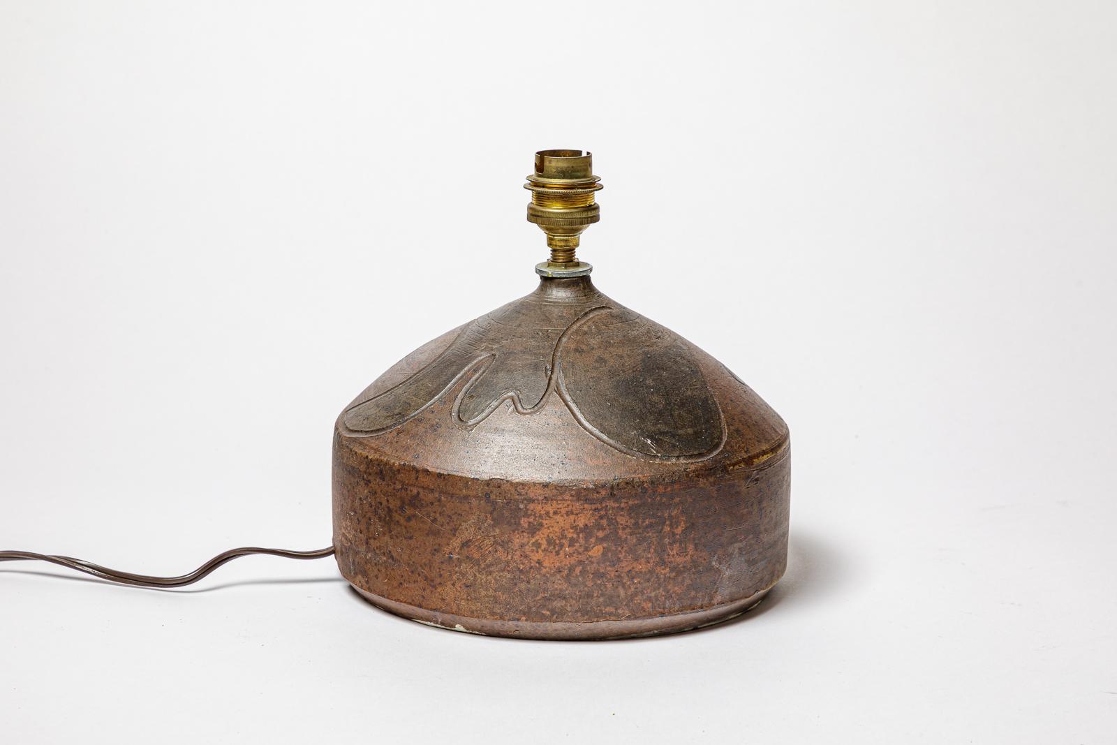 Lampe en grès à décor géométrique par Georges Martin.
Monogramme de l'Artistics sur la base. Circa 1970-1980.
H : 5.5 x 7.7 pouces (céramique uniquement).
Vendu avec un système électrique européen.