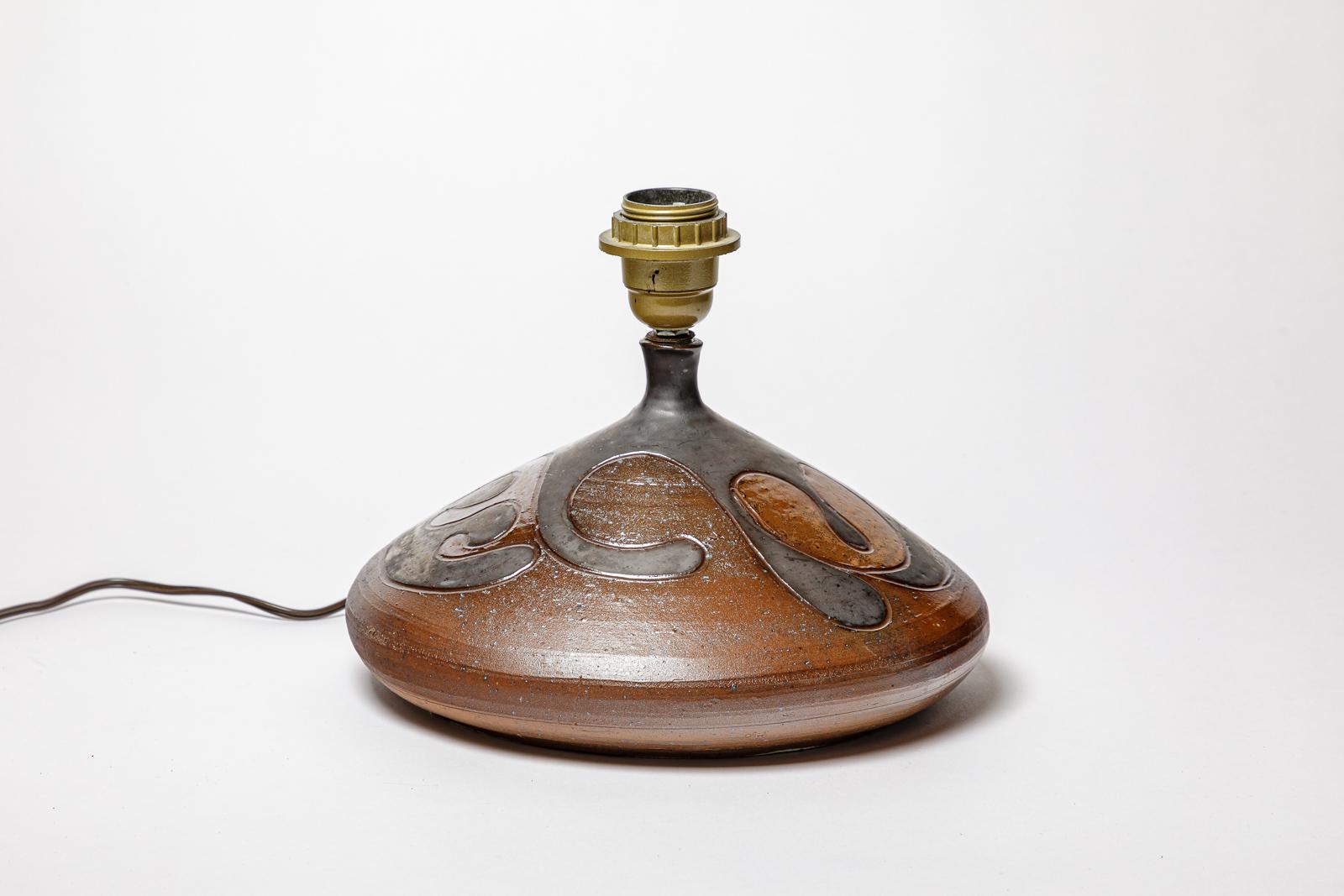 Lampe en grès à décor géométrique par Georges Martin.
Monogramme de l'Artistics sur la base. Circa 1970-1980.
H : 5.9 x 10.2 pouces (céramique uniquement).
Vendu avec un système électrique européen.