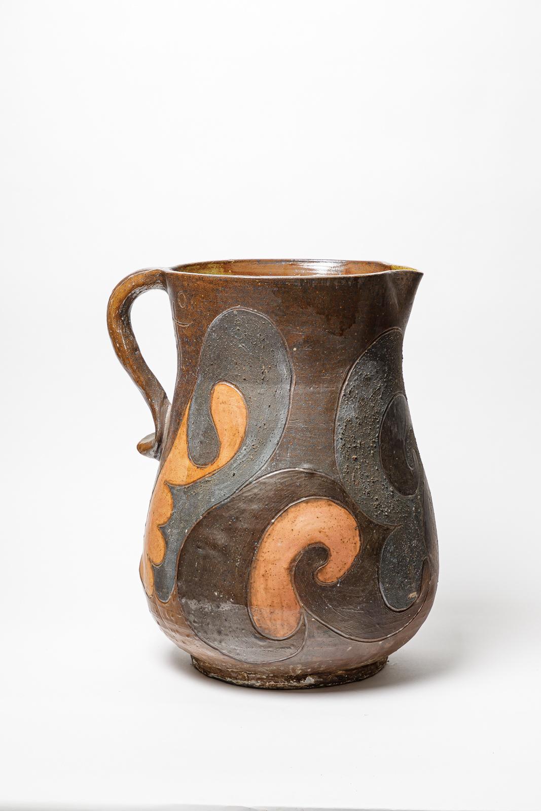 Pichet en grès de Georges Martin avec décor émaillé.
Monogramme de l'Artistics sur la base. 
Pièce unique.
Circa 1970-1980.
H : 18.1 x 12.9 x 14.2 pouces.
