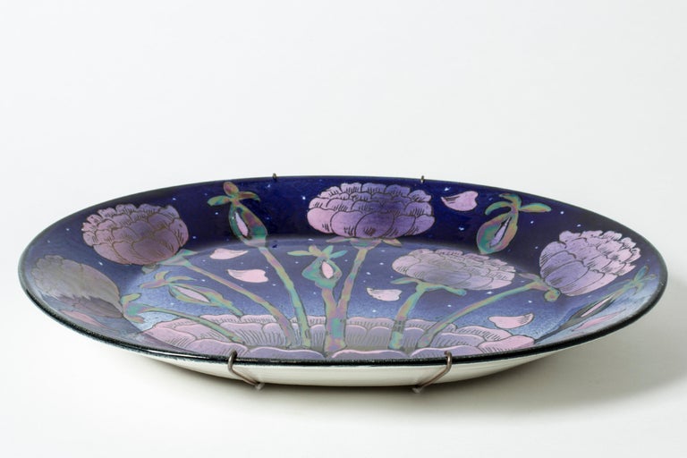 Amazing, unique stoneware platter by Birger Kaipiainen in an oval form. Otherwordly motif of purple roses and rose petals against a starry night sky. Iridescent glaze adds to the ethereal expression.