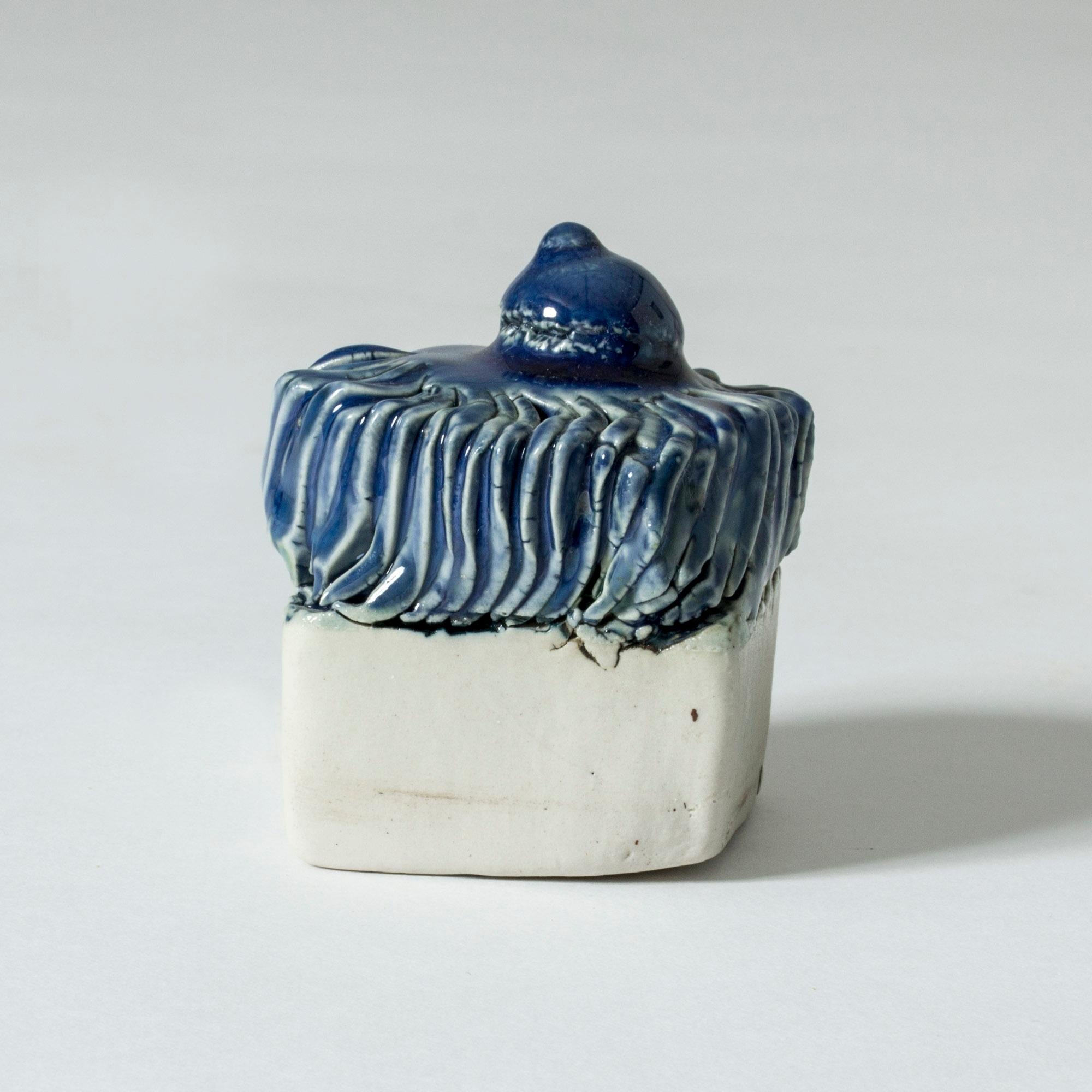 Small stoneware sculpture by Bengt Berglund in a suggestive, whimsical shape, blue glaze on top, unglazed from the middle and down.