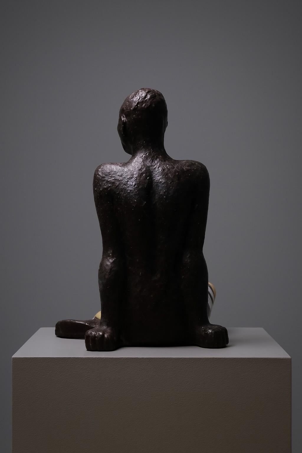 Sculpture modèle 81 conçue par Vicke Lindstrand pour Upsala-Ekeby en Suède en 1947-48. Remarquable figure en céramique de grande taille représentant une femme assise au corps sombre et aux draperies à motifs vivement émaillés en jaune, blanc et