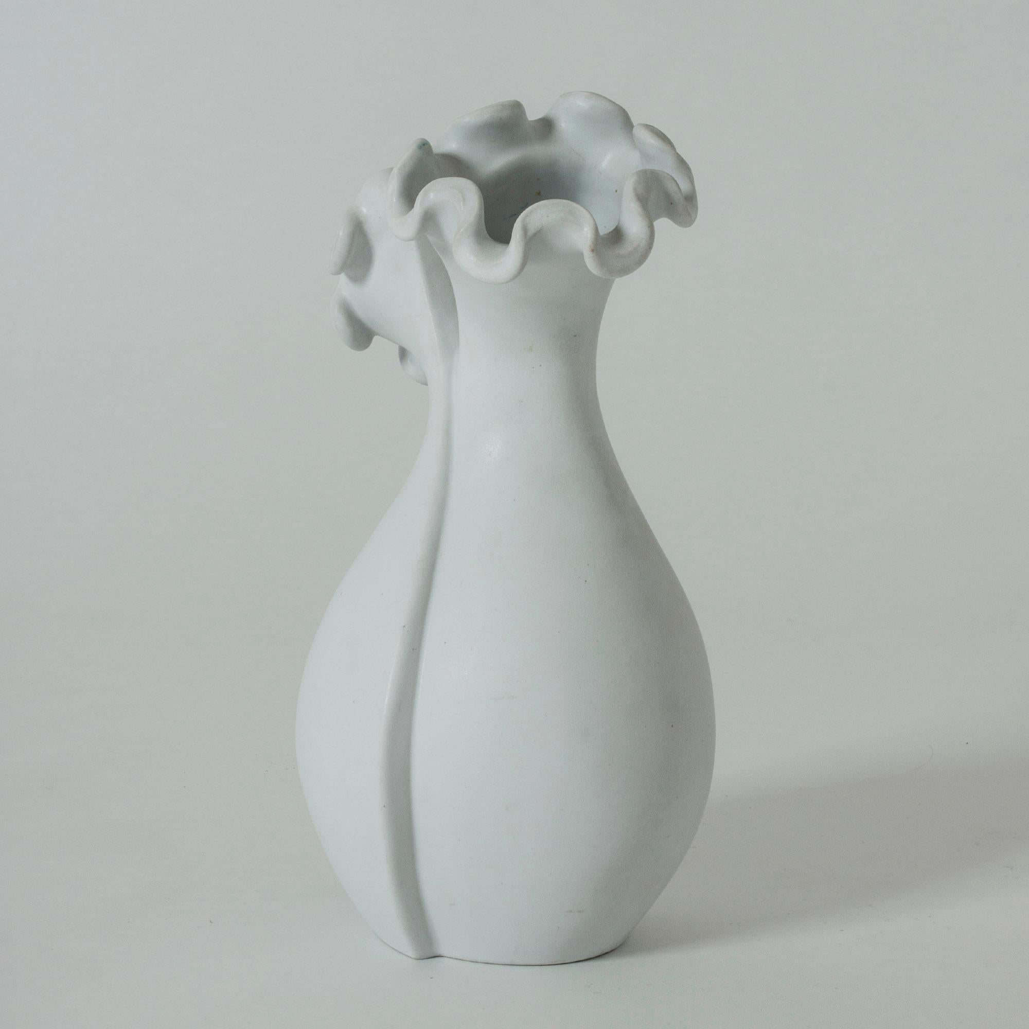 Beautiful “Surrea” vase by Wilhelm Kåge, made in Carrara stoneware. The skewed form grows into two openings with the characteristic wavy “Våga” decor around the rims. The fascinating design is a combination of two of Kåge’s best known lines of