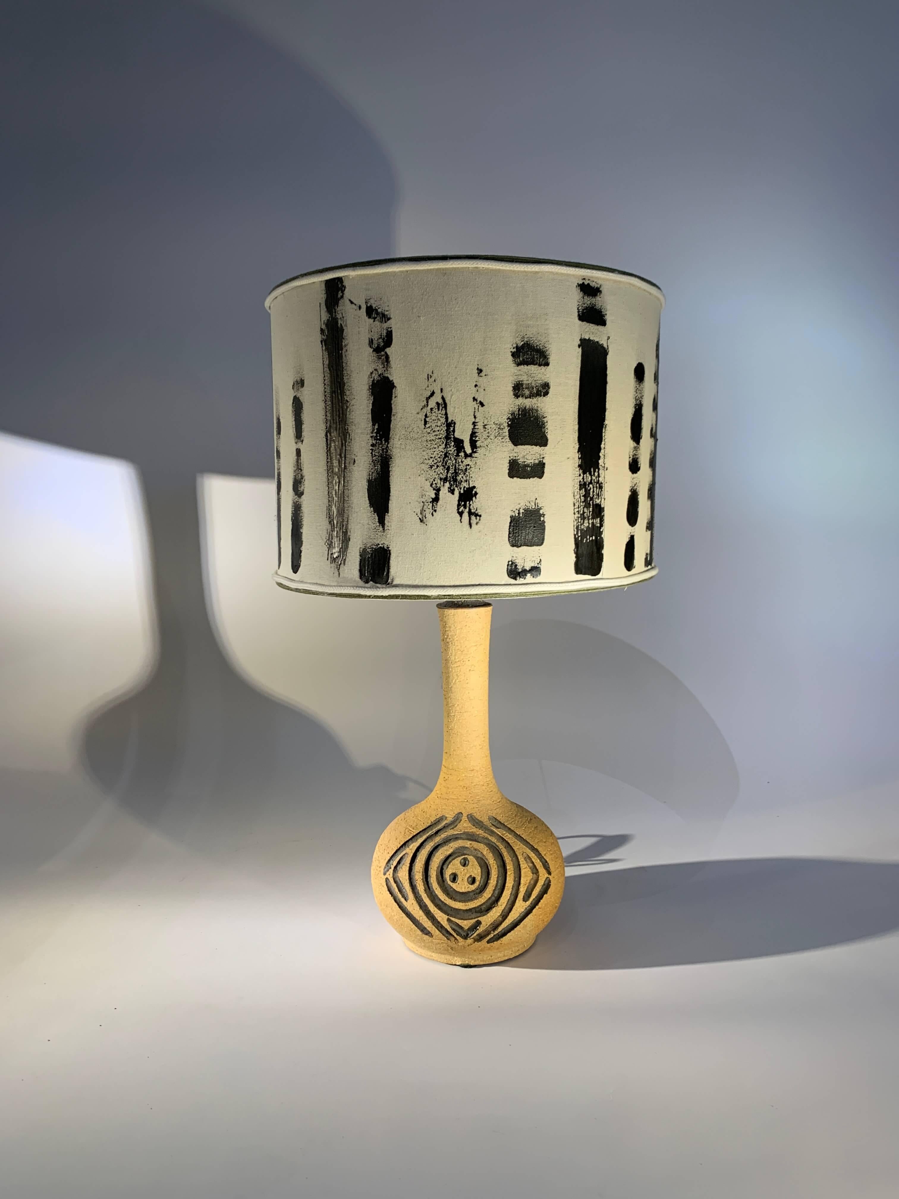 Tall, slender lamp with incised decoration in a Brutalist style. 
Handmade stoneware in very good condition, signed.
Dimensions:
H35cm x W18cm without lampshade & socket.
H61cm x W35cm with lampshade.
Denmark, circa 1970