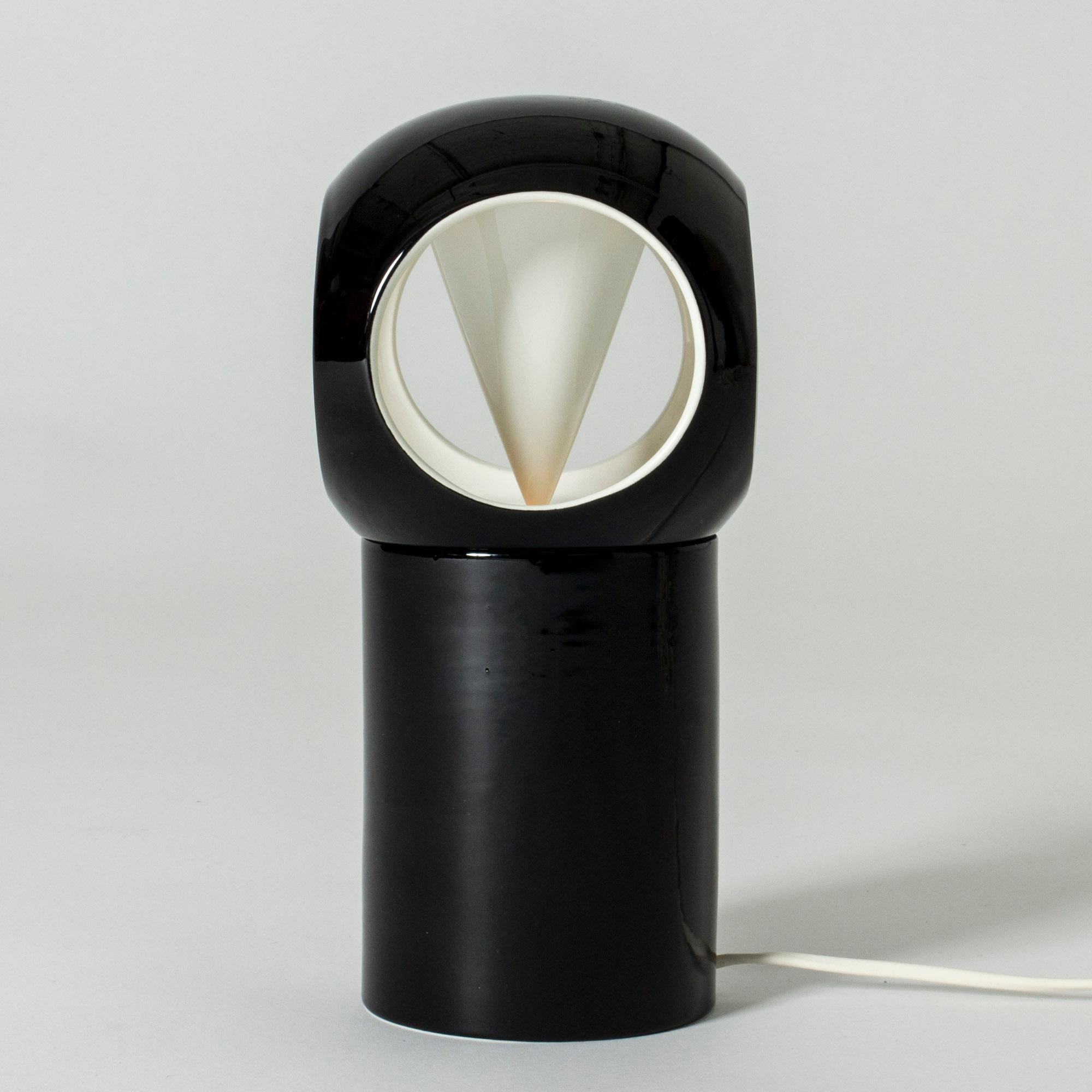 Striking table lamp by Carl-Harry Stålhane, made from stoneware. Glazed contrasting black and white. Looks different depending on angle, the openings in the shade give it an owl-like look.

Carl-Harry Stålhane was one of the stars among Swedish
