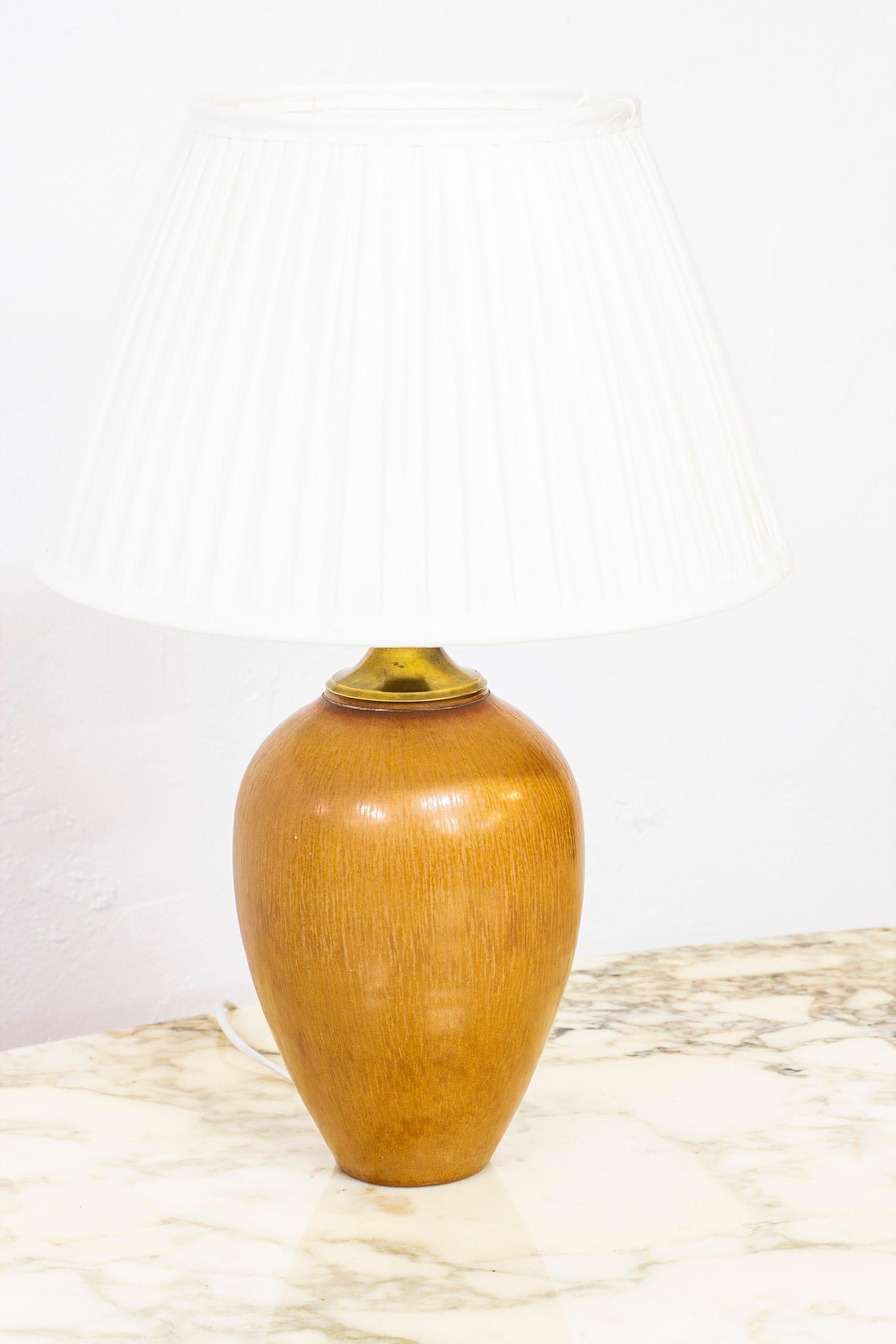 Table lamp designed by Gunnar Nylund. Produced in Sweden by Rörstrand during the 1940s-1950s. Handmade from stoneware with brown 