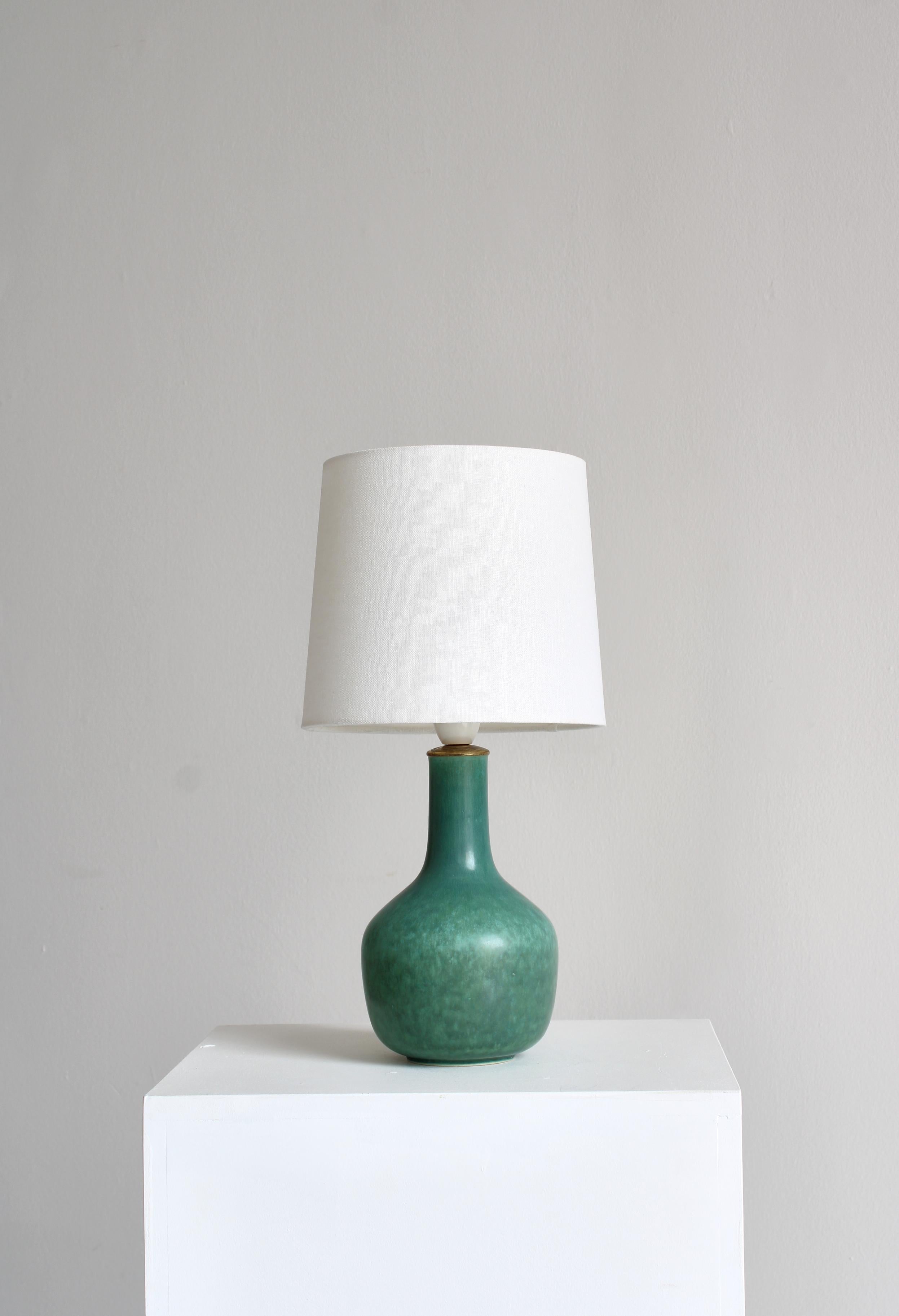 Rare lampe de table en grès modèle 469 de la poterie Saxbo, Danemark. Fabriquée par Eva Staehr-Nielsen dans les années 1940 et décorée d'un merveilleux glaçage vert en forme de lièvre. Monture originale en laiton et bakélite. Signé 