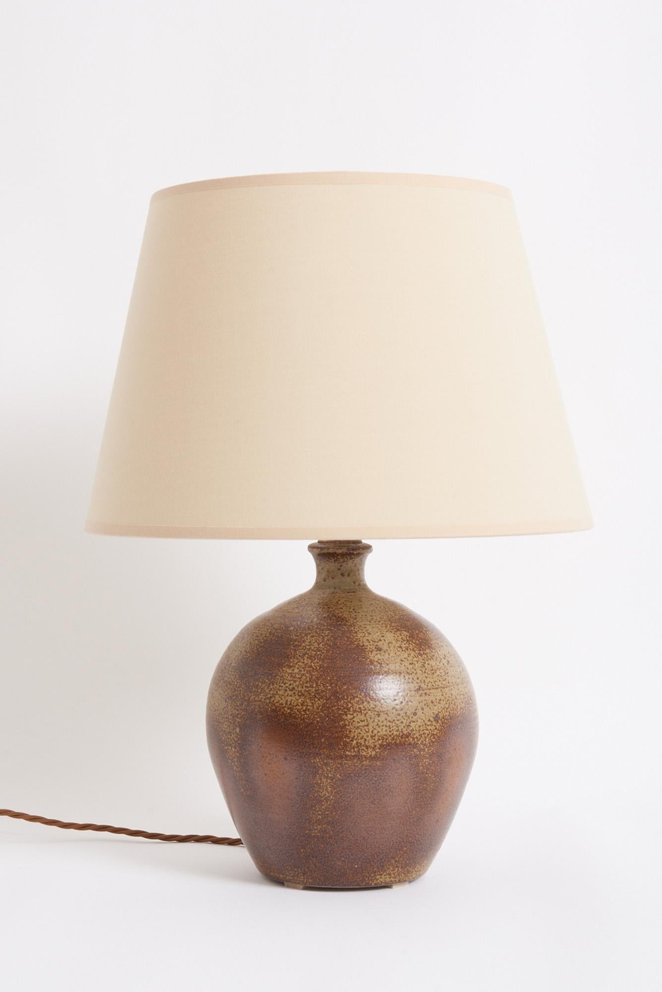 A turned stoneware table lamp.
France, 1960s
With the shade: 48 cm high by 35 cm diameter
Lamp base only: 30 cm high by 20 cm diameter