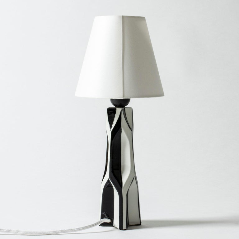 Pair of amazing stoneware table lamps by Carl-Harry Stålhane. Graphical, sculptural bodies with slightly altering heights which is evened out by the height of the brass handles. Striking black and white decor.