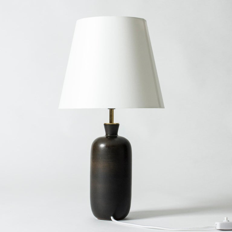Elegant table lamp by Carl-Harry Stålhane, with a stoneware base in a smooth, strict form. Glazed dark brown with beautiful, subtle nuances.