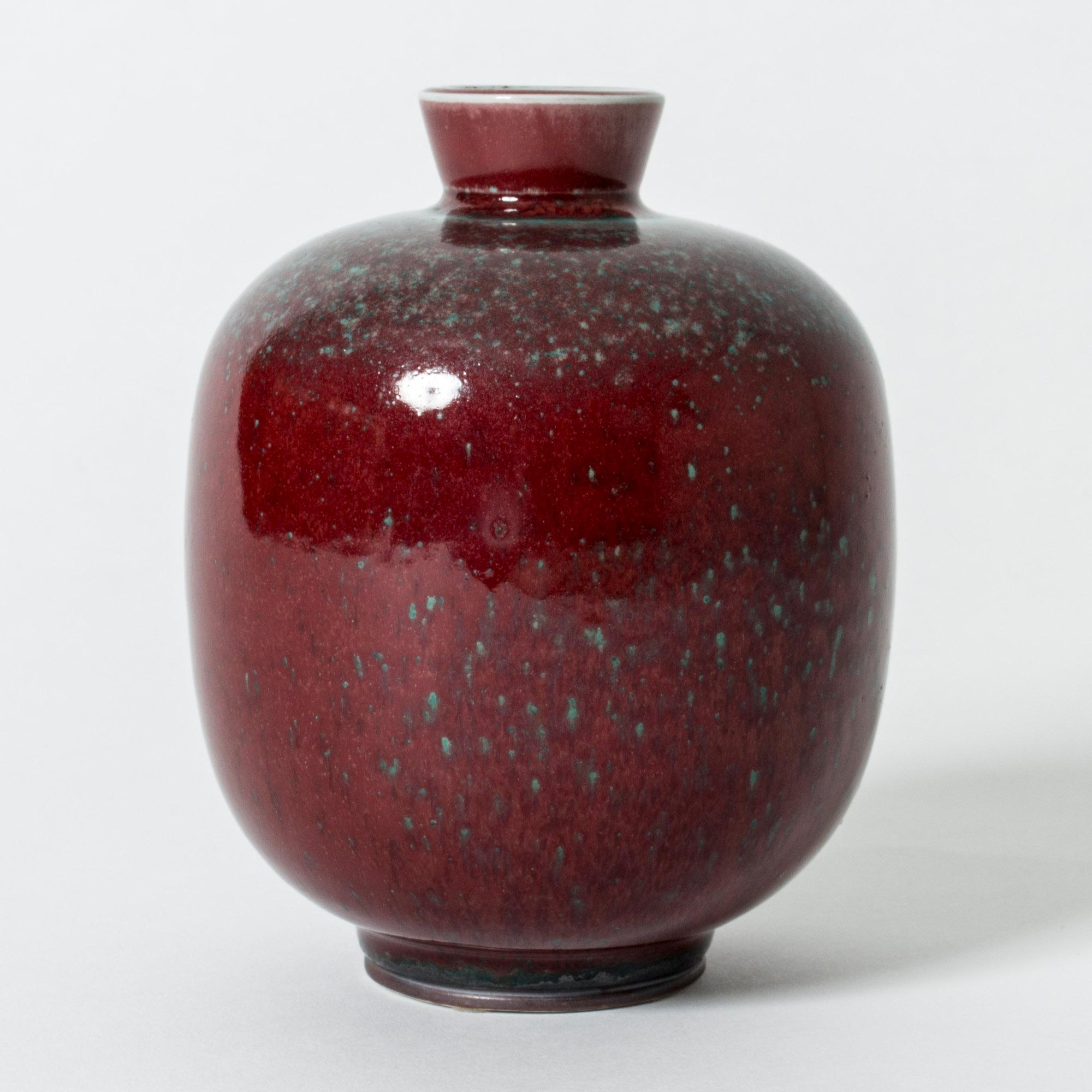 Stoneware vase by Berndt Friberg in plump form with deep and lustrous oxblood glaze, contrasted with blueish-green speckles.