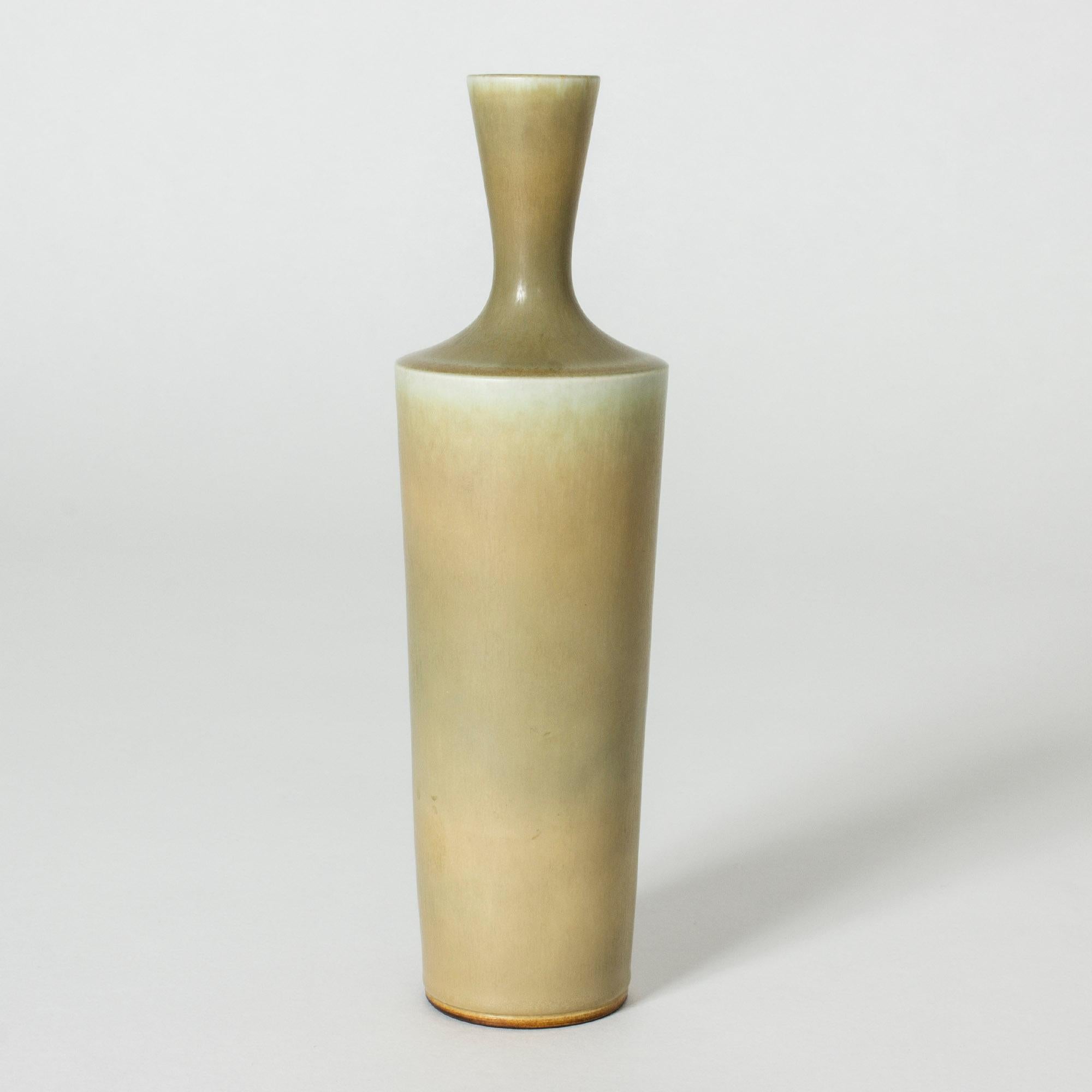 Stoneware vase by Berndt Friberg, in a stately shape with a sharp finish to the body where it transitions to the nozzle. Pale yellow hare’s fur glaze.