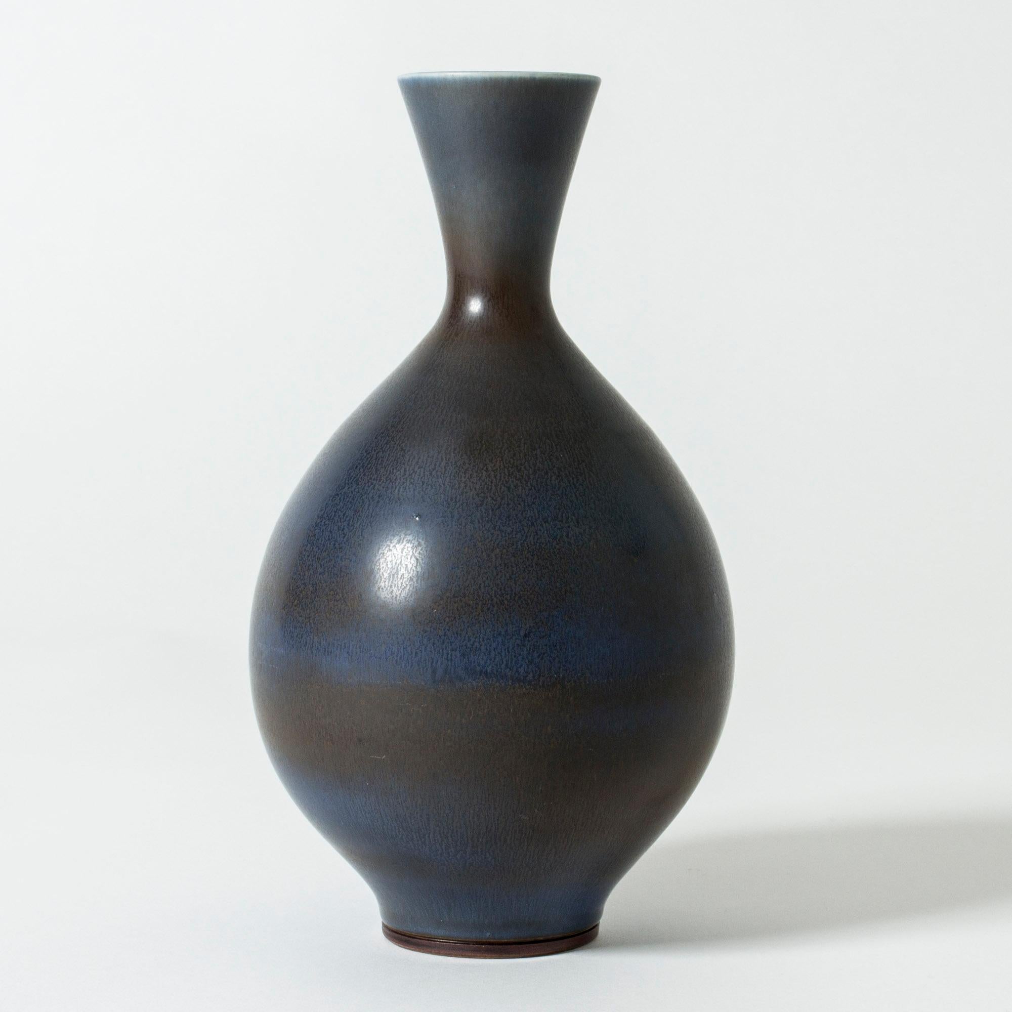 Beautiful stoneware vase by Berndt Friberg, in classic, plump form. Dark blue and brown hare’s fur glaze blending into each other over the body.

Berndt Friberg was a Swedish ceramicist, renowned for his stoneware vases and vessels for