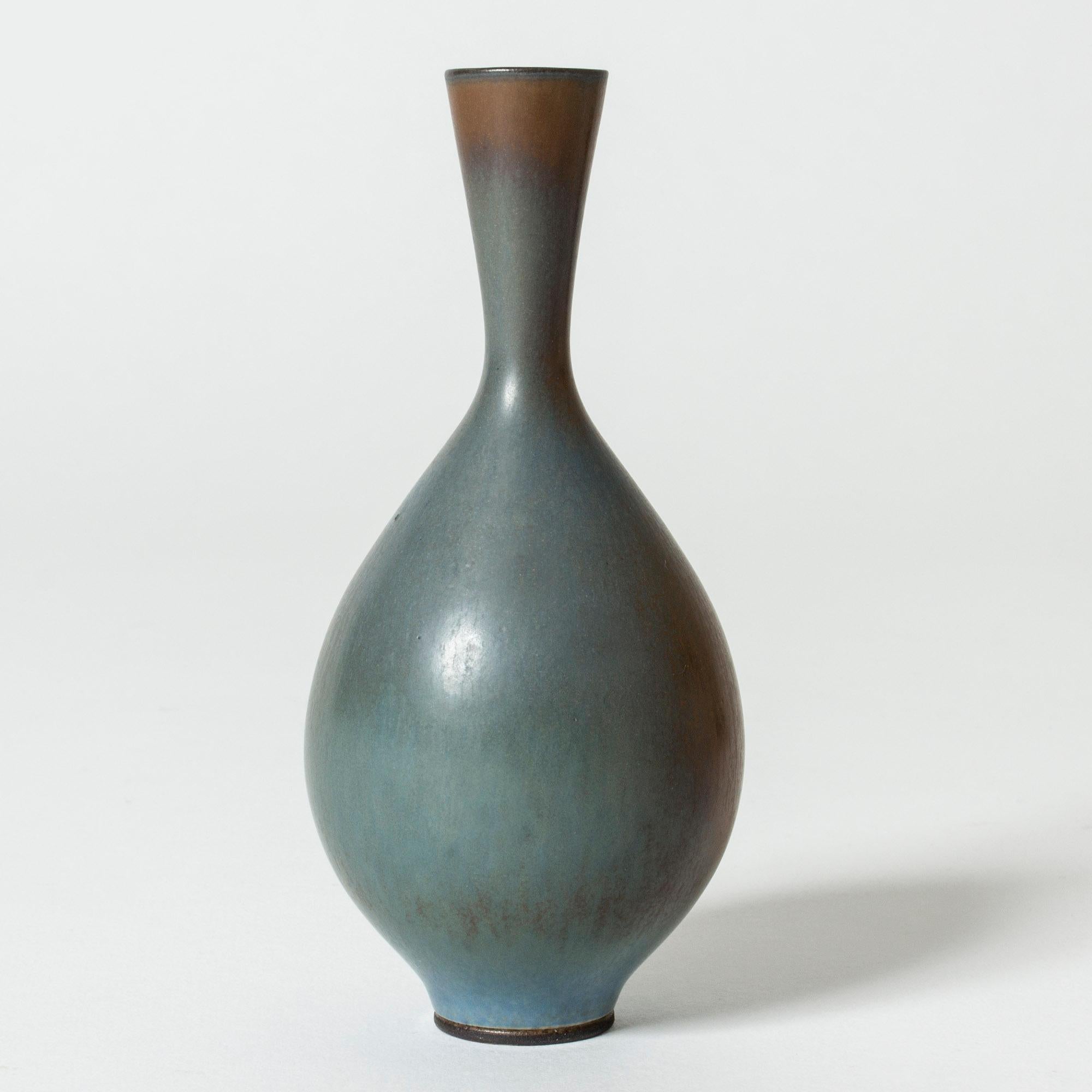 Lovely stoneware vase by Berndt Friberg in a bulbous form. Blue glaze with rust colored fields.

Berndt Friberg was a Swedish ceramicist, renowned for his stoneware vases and vessels for Gustavsberg. His pure, composed designs with satiny,