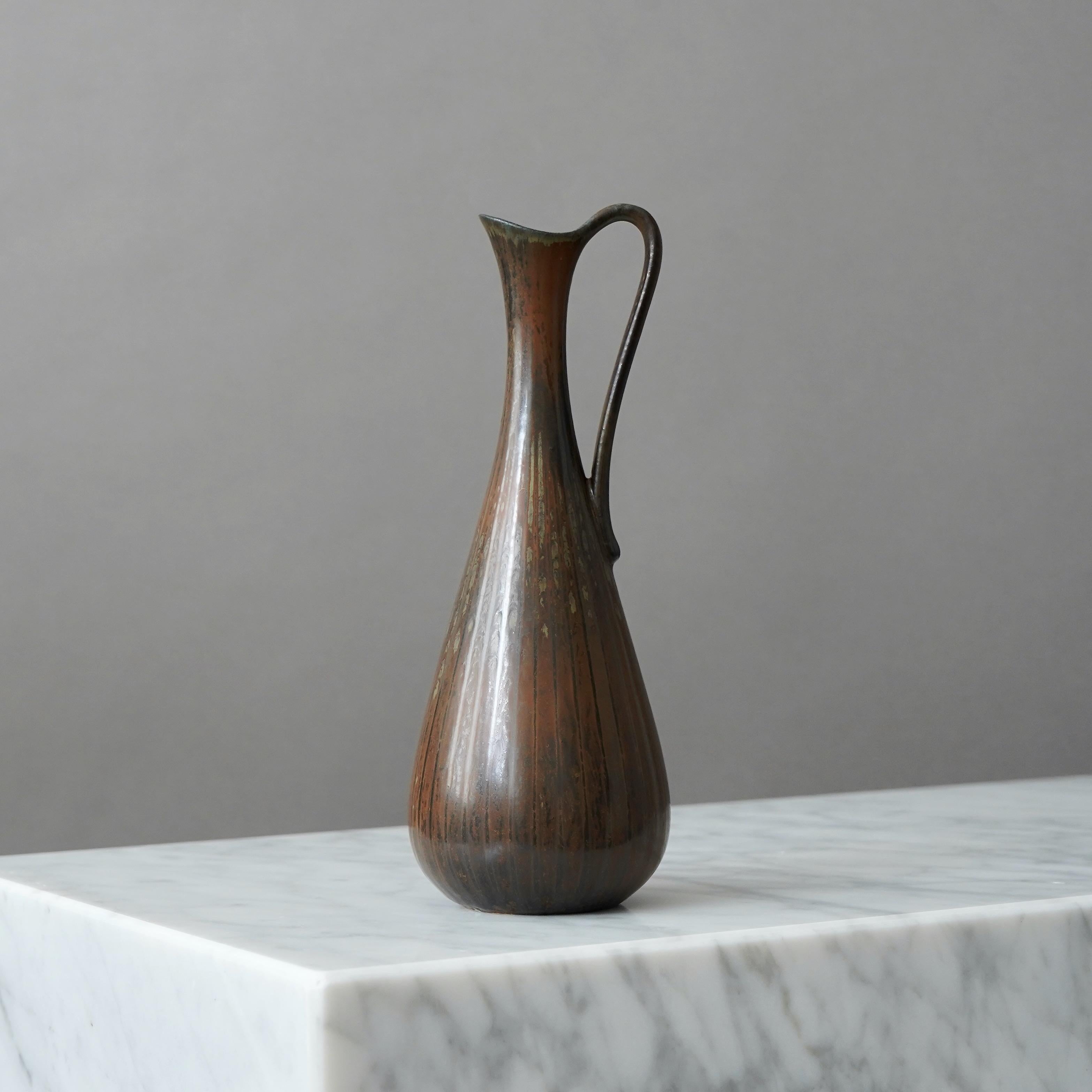 Magnifique vase en grès avec anse. 
Conçu par Gunnar Nylund pour Rorstrand, Suède, années 1950.  

Excellent état. Signature incisée 