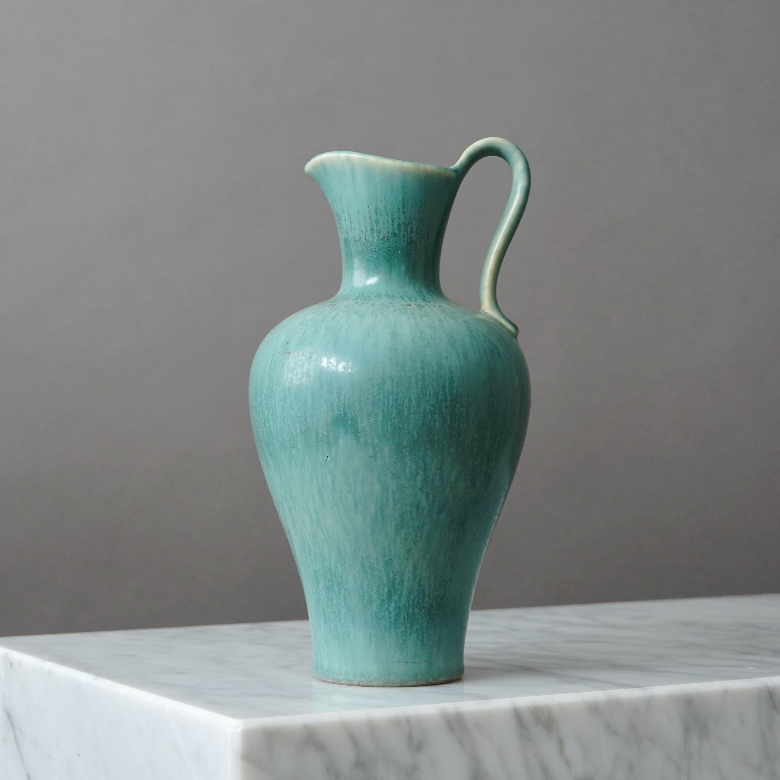 Un bellissimo vaso in gres con manico e smalto sorprendente.
Disegnata da Gunnar Nylund per Rorstrand, Svezia, anni '1950.  

Ottime condizioni, alcune piccole macchie di smalto. 
Firma incisa 