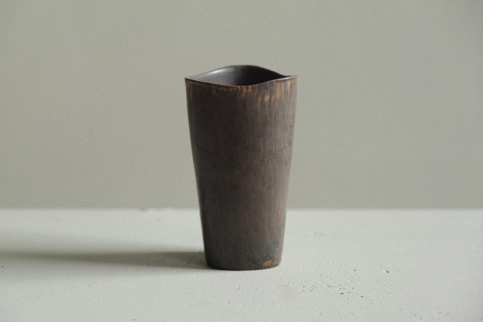 Vaso in gres dalla forma pulita di Gunnar Nylund; il bordo ondulato ammorbidisce la forma. Vivace smalto marrone e arancione.

Firmato sotto. 

Gunnar Nylund è stato uno dei ceramisti e designer più influenti della metà del secolo scorso in