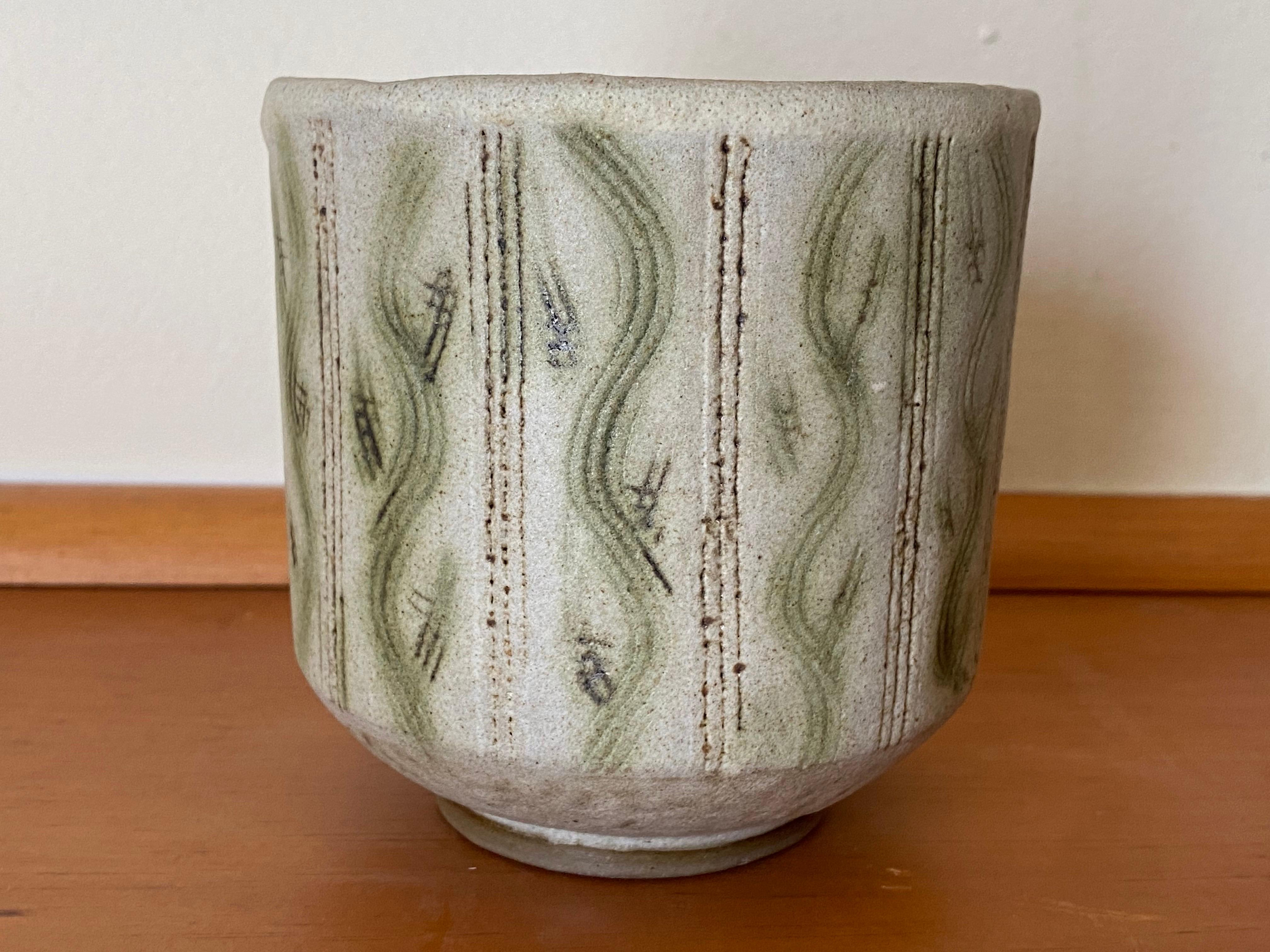 Vaso in gres della fine degli anni '40 di Nancy Wickham Boyd, caratterizzato da un dinamico motivo a sgrafitto a forma di vite, evidenziato da una smaltatura verde. Come molti noti ceramisti di New York, Nancy ha iniziato a lavorare per alcuni anni