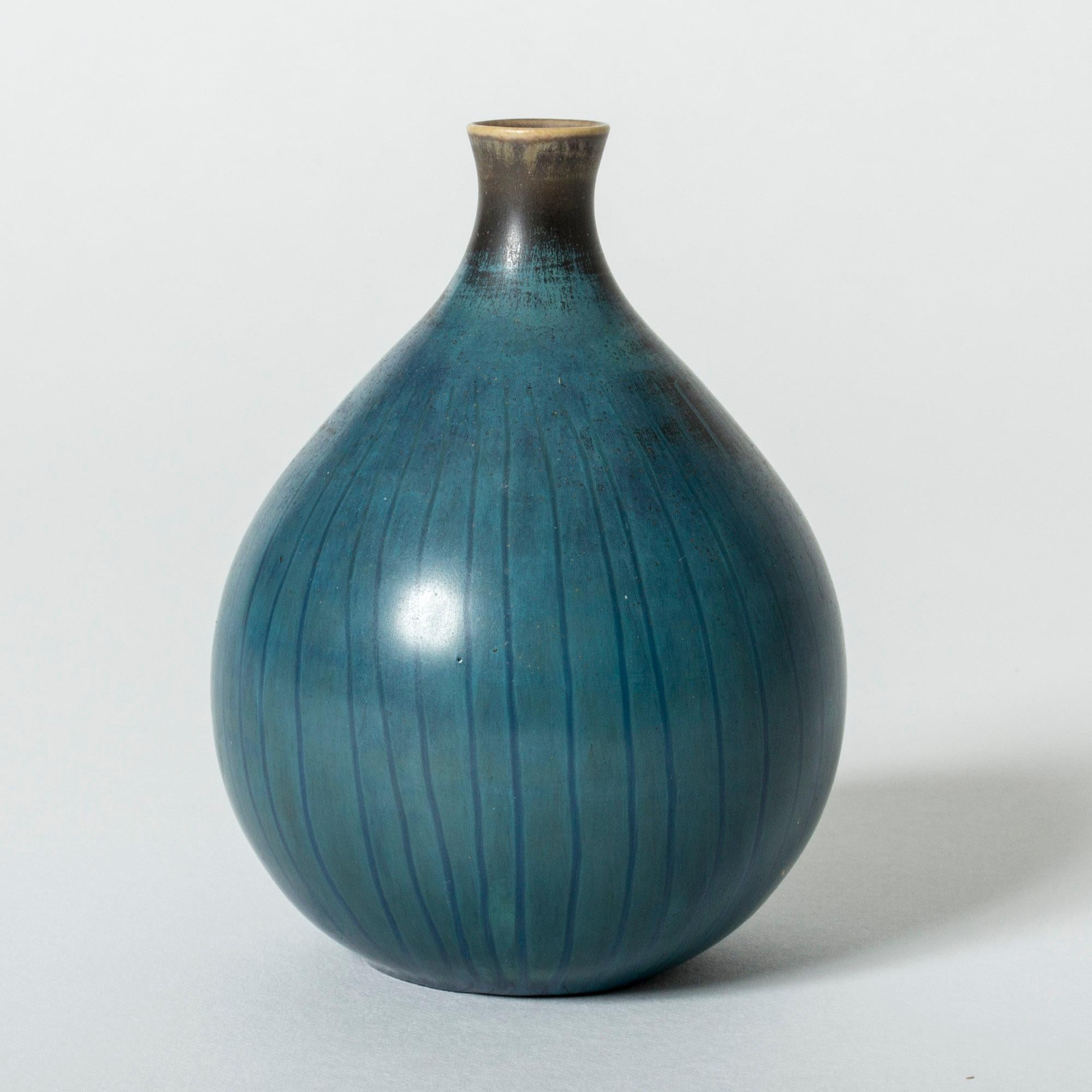 Stoneware vase by Stig Lindberg, in a small, onion shaped form. Blue glaze with subtle stripes, brown around the mouth.