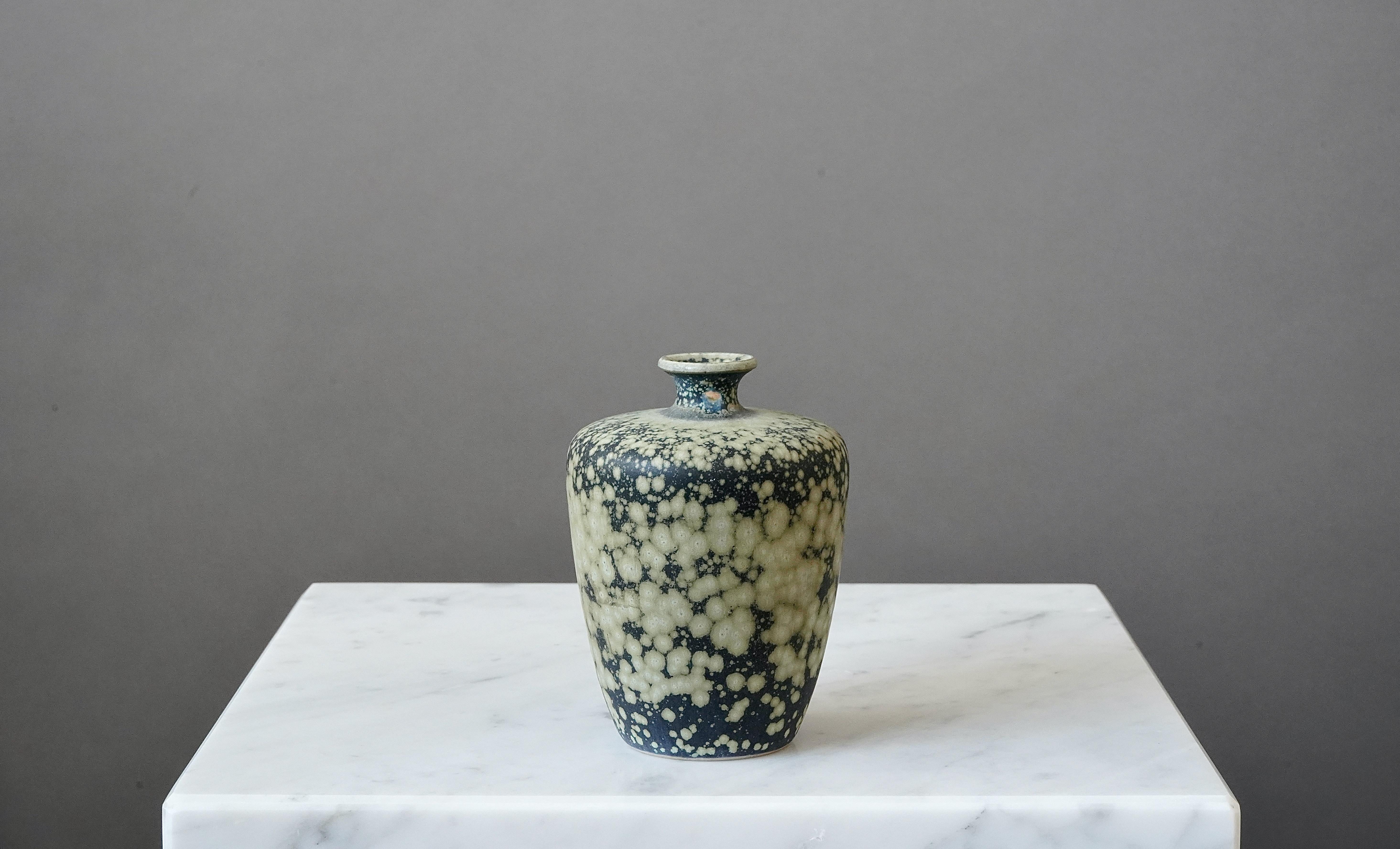 A beautiful small stoneware vase with amazing glaze. 
Made by Rolf Palm, in the artist's studio, Mölle, Sweden, 1980.

Incised ’Palm / Mölle / H0’ and marked ’413’.
Good overall condition, but the vase has a glaze flaw on the neck, from