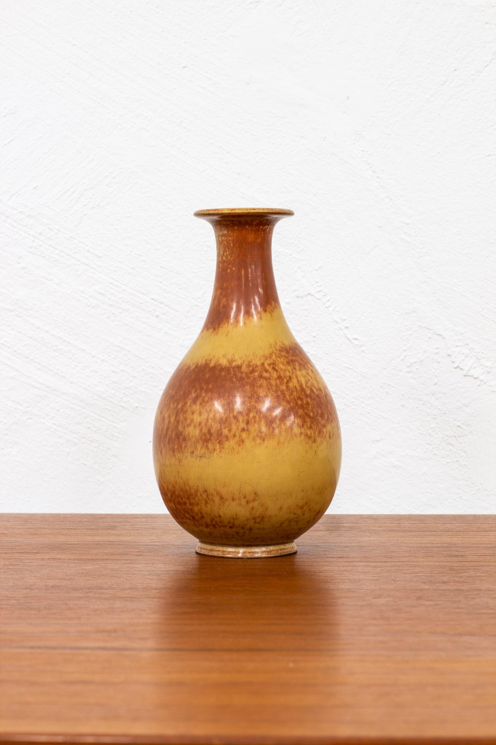 Stoneware vase designed by Gunnar Nylund. Hand made at Rörstrand in the 1940s. Glaze with burnt brown tones. Very good vintage condition with light wear and patina.

Dimensions: H. 24 Ø. 14 cm.

