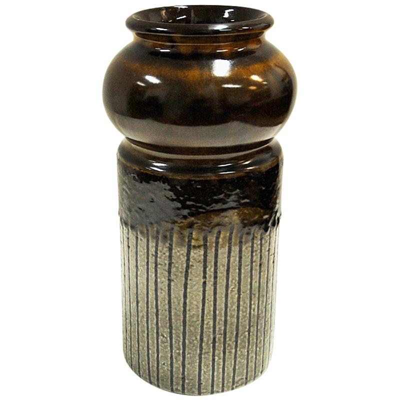 Joli vase en poterie marron de couleur terre de la gamme `Moske` du designer Mari Simmulson- produit pour Upsala Ekeby en 1967. Le vase Moske a une surface rugueuse et rustique et une forme particulière. Magnifique tel quel ou avec des échasses de