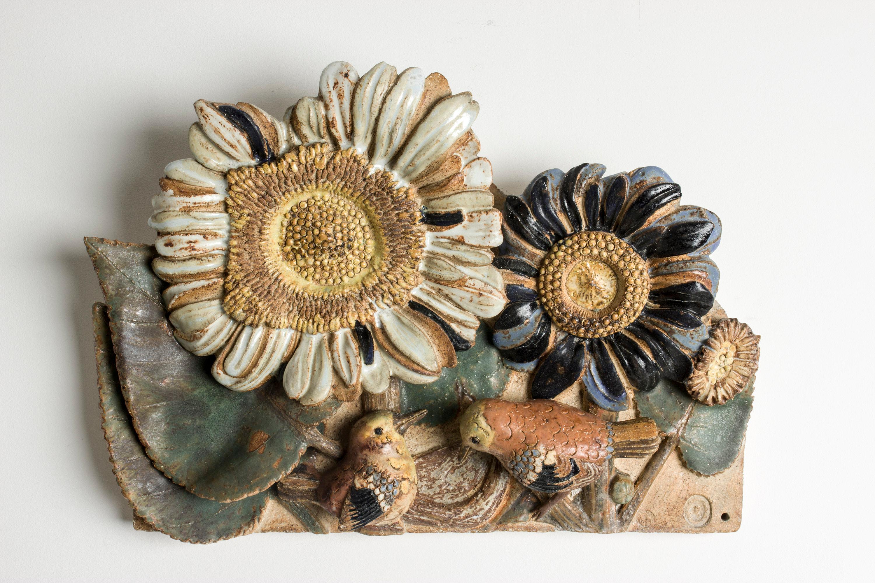 Striking stoneware wall relief by Tyra Lundgren, in a colorful, buoyant design of sunflowers and birds. Birds, delicate and expressive, were a recurring theme in Tyra Lundgren’s work. The wall reliefs were often made so that they could be arranged