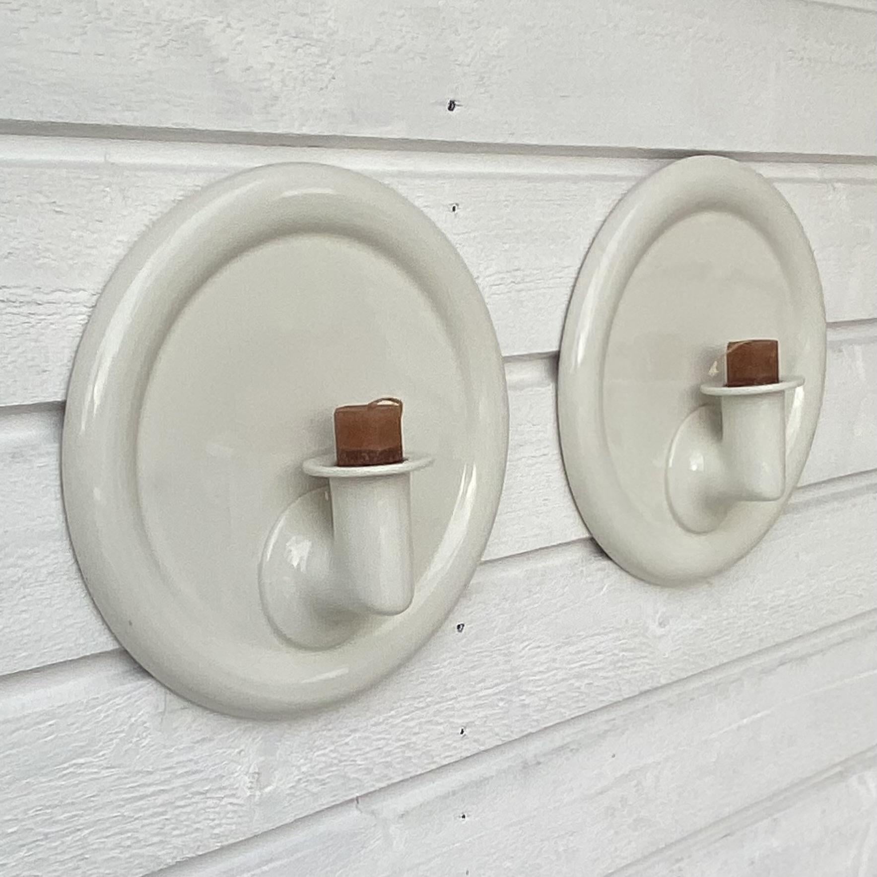 A pair of stoneware wall sconces designed by the Swedish ceramic artist Margareta Hennix for the Gustavsberg porcelain factory. These sconces boast a minimalistic design and provide a holder for a single pillar candle each. The artist Margareta