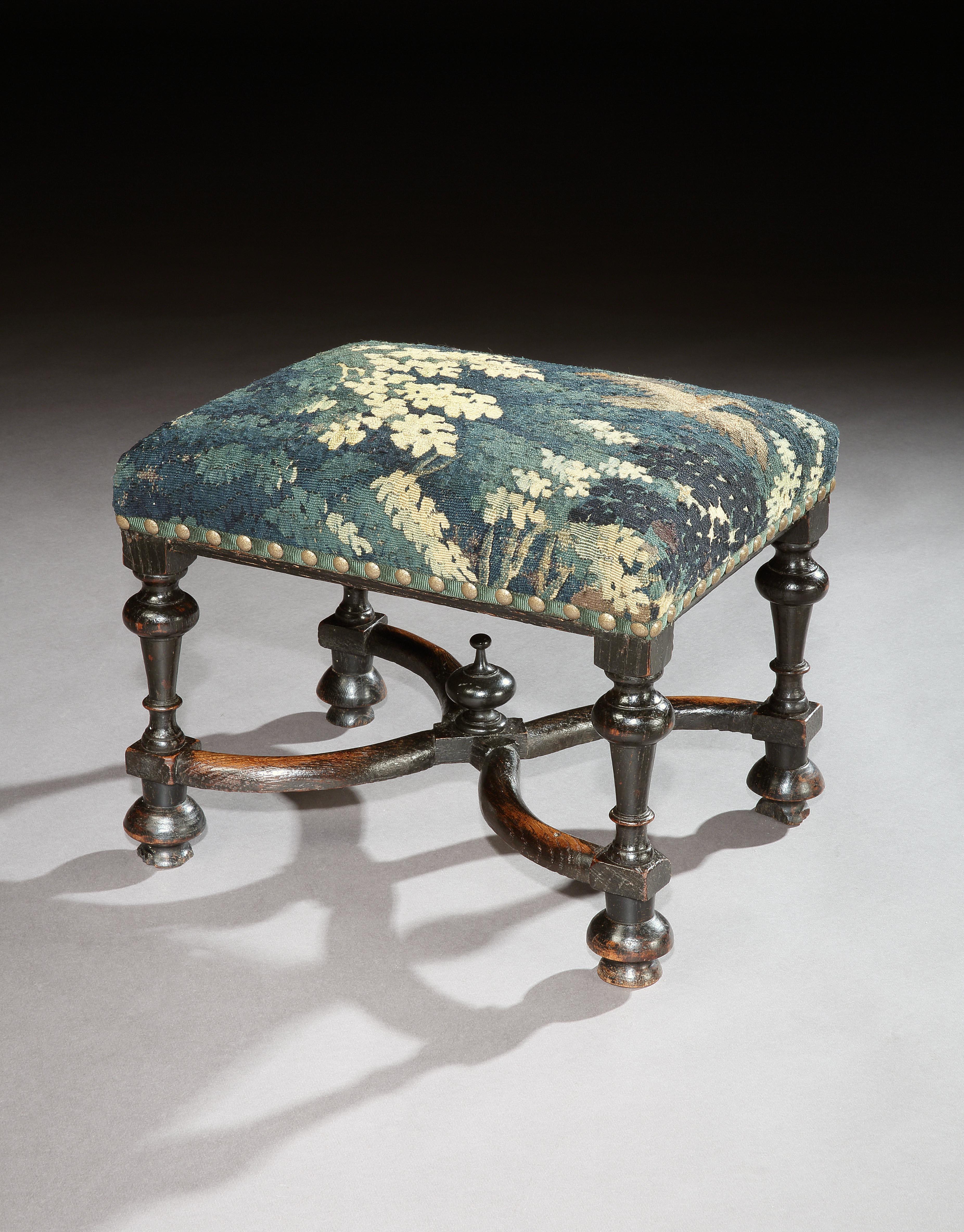 A rare, late 17th century. ‘X’ stretchered, ebonised, oak stool upholstered in 17th century verdure tapestry
Unusual simulating ebony which was phenomenally expensive and only found in Royal and aristocratic collections at this time
This stool is