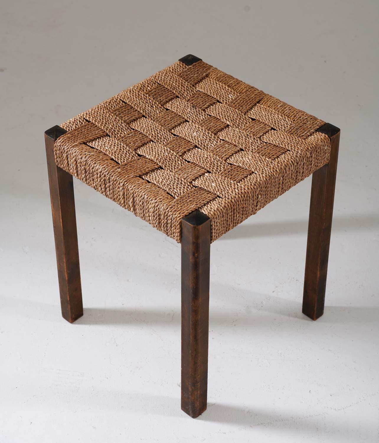 This Swedish modern stool designed by Axel Larsson for Bodafors in the 1930s offers a distinctive blend of craftsmanship and historical allure. Constructed from stained birch and featuring seagrass webbing, these stools epitomise the design