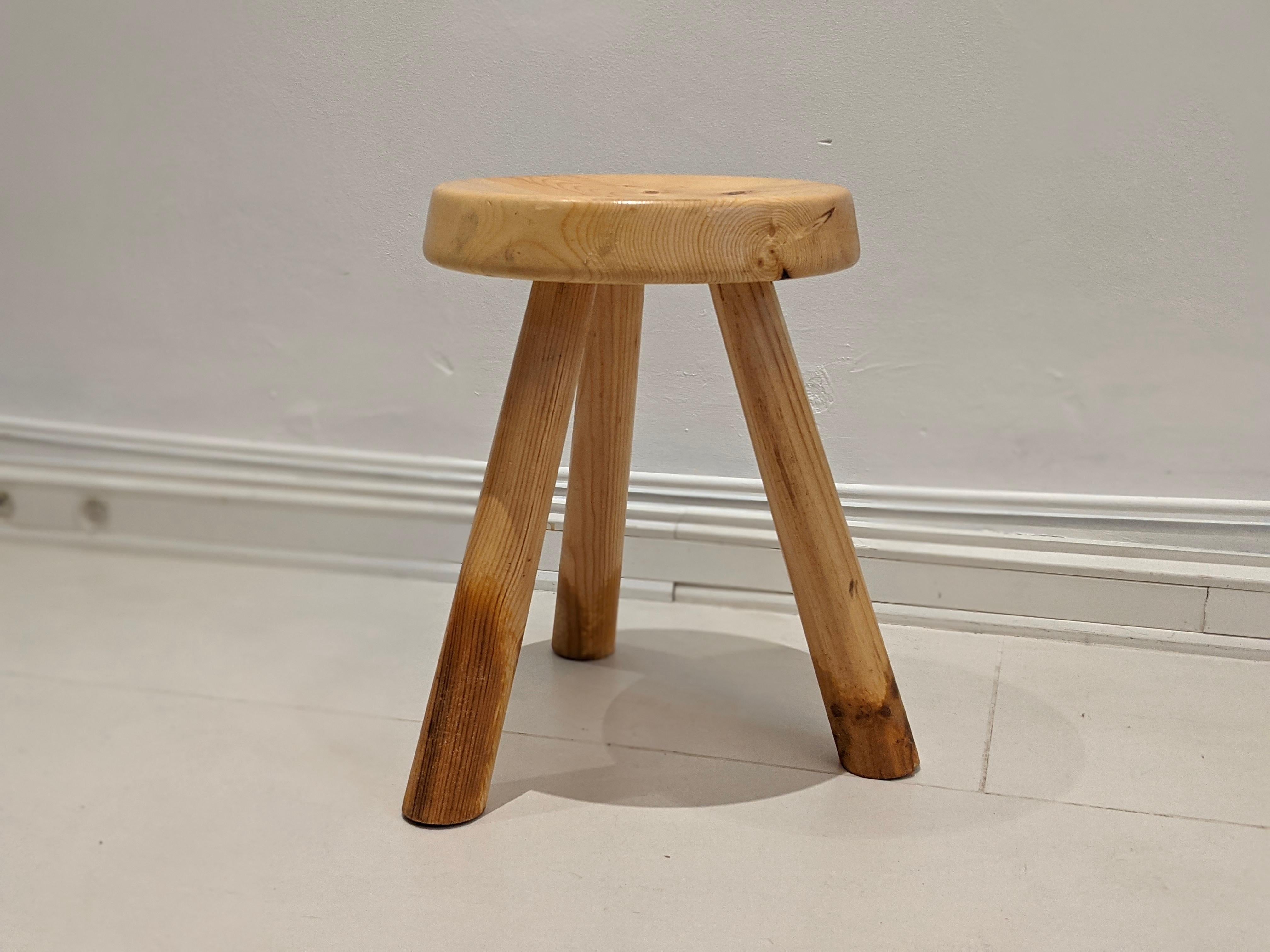 Low and tripod stool in pinewood by Charlotte Perriand for Les Arcs. Good condition, light signs of wear on the legs consistent with age and use.