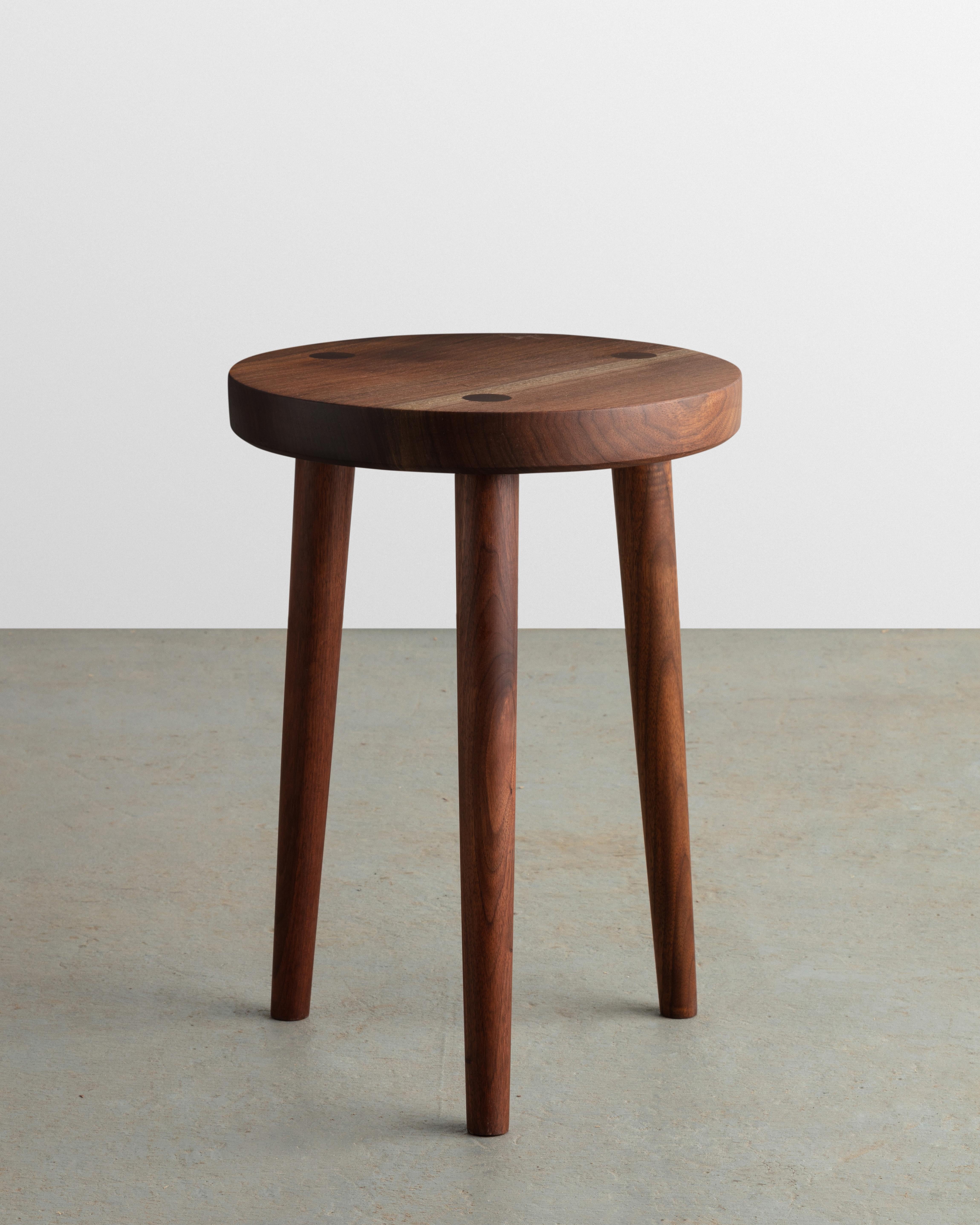 Constructed from solid walnut, this hand-turned three-legged stool is built to last. All pieces are made to order and no two are alike.