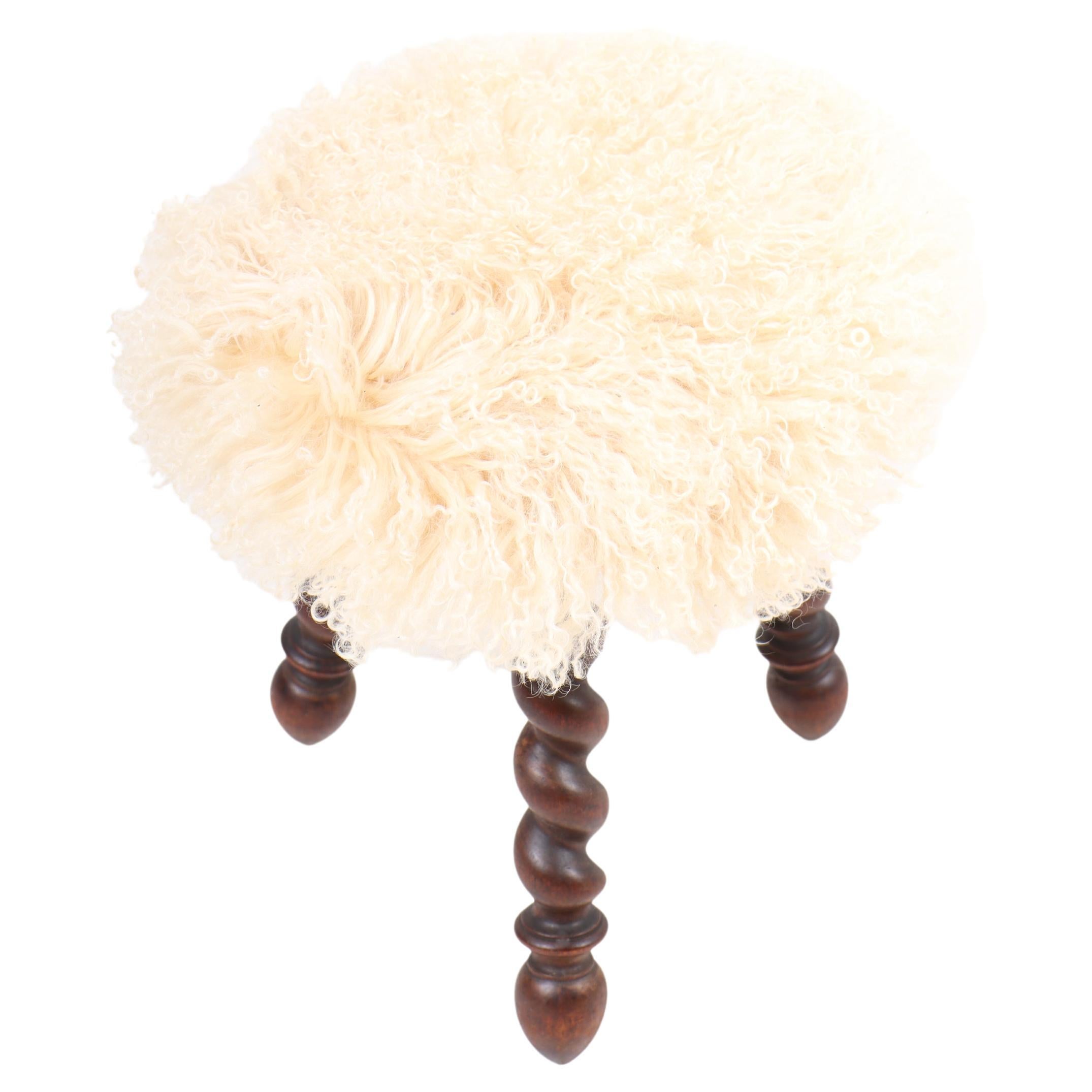 Stool in mahogany with in new sheepskin seat, designed and made in Sweden, circa 1930.