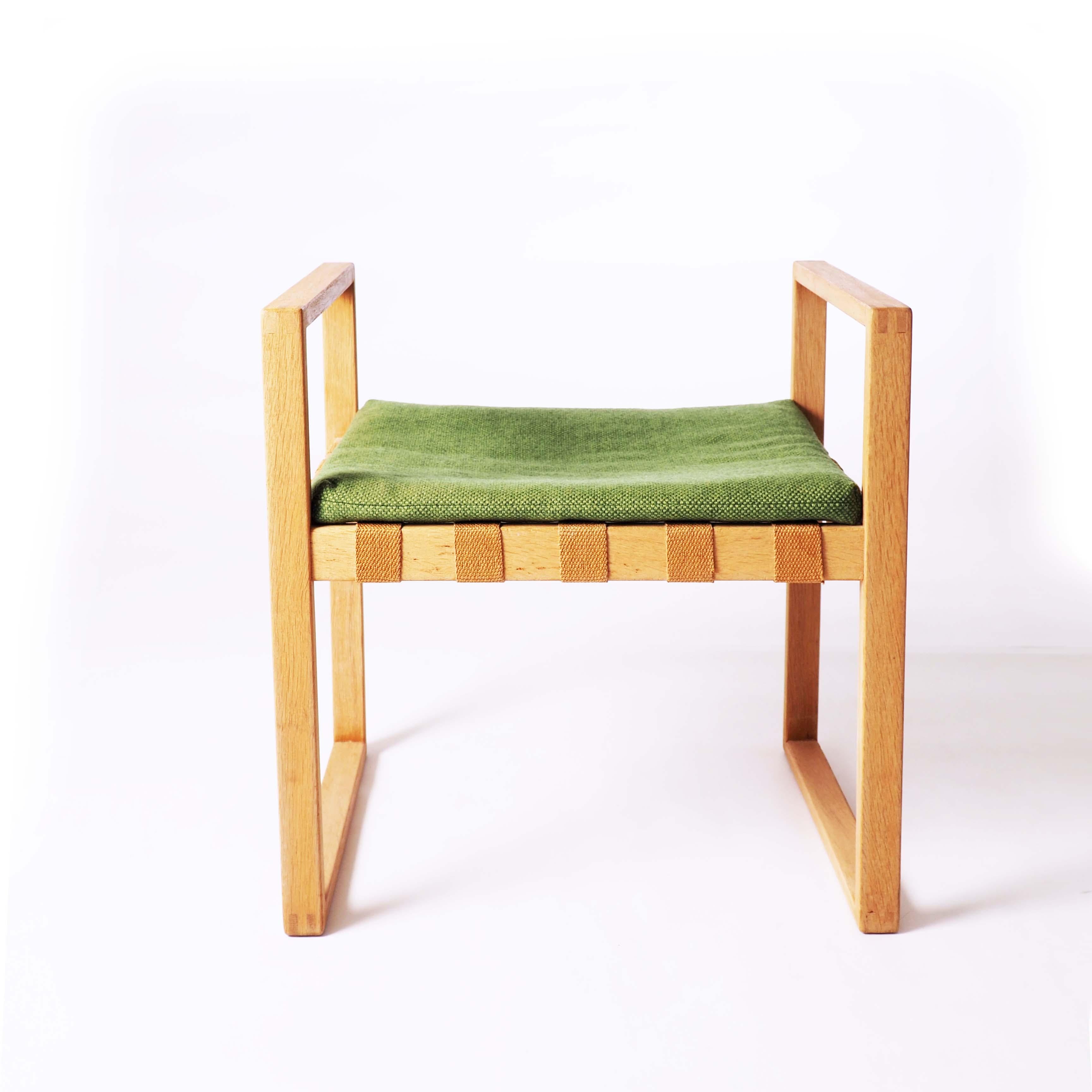 This stool was designed by Swedish designer Åke Fribyter and made in solid oak at Nybrofabriken, Fröseke. The details in the woodwork are in high quality. The pad has got the original upholstery in wool and is in very good condition.