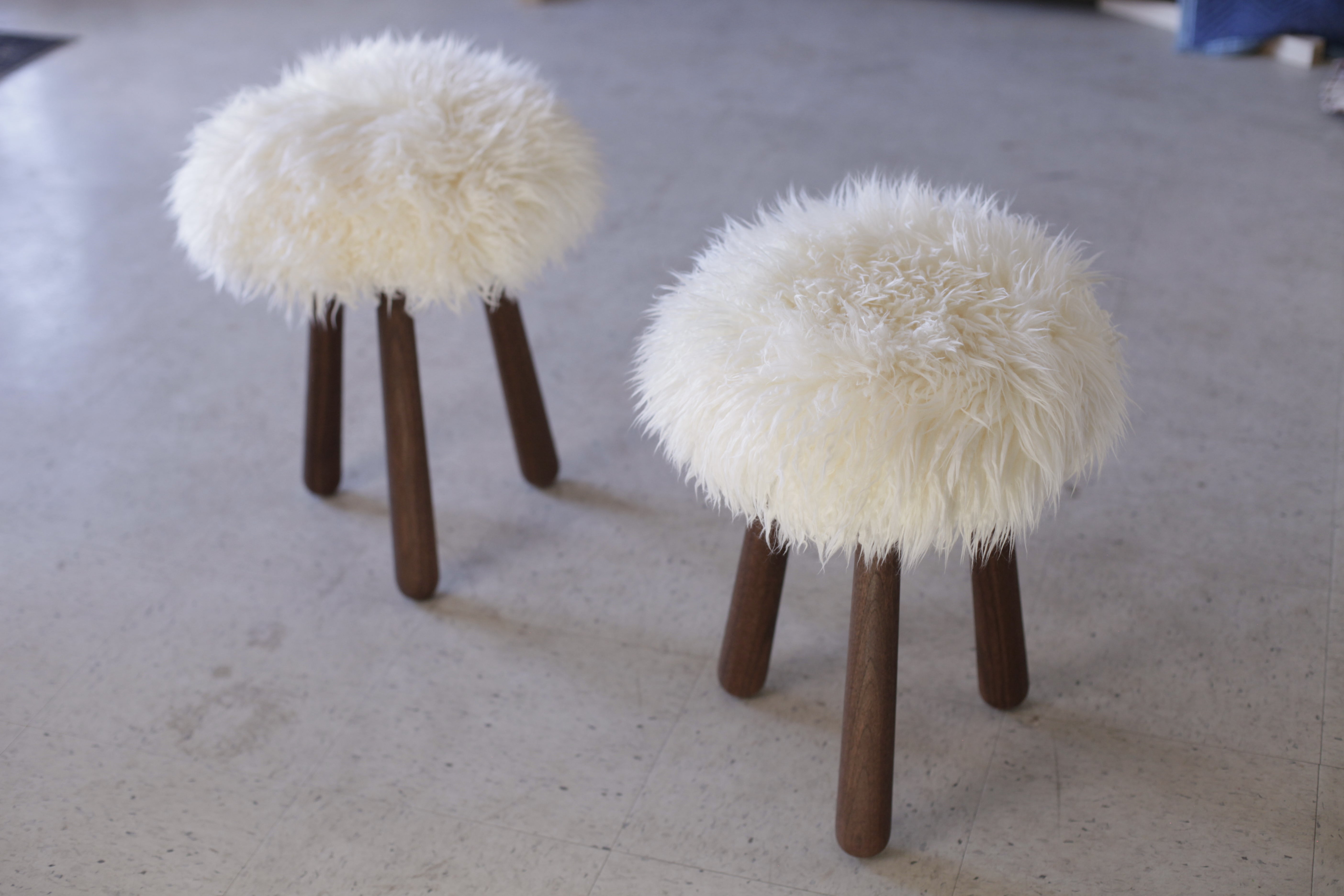 This stool in shearling and walnut is very cute and very soft. It's also nice to sit on. We source a quality sheepskin with long, wavy fleece. The legs are angled and gently flare as they reach the ground. We utilize one of the oldest methods of