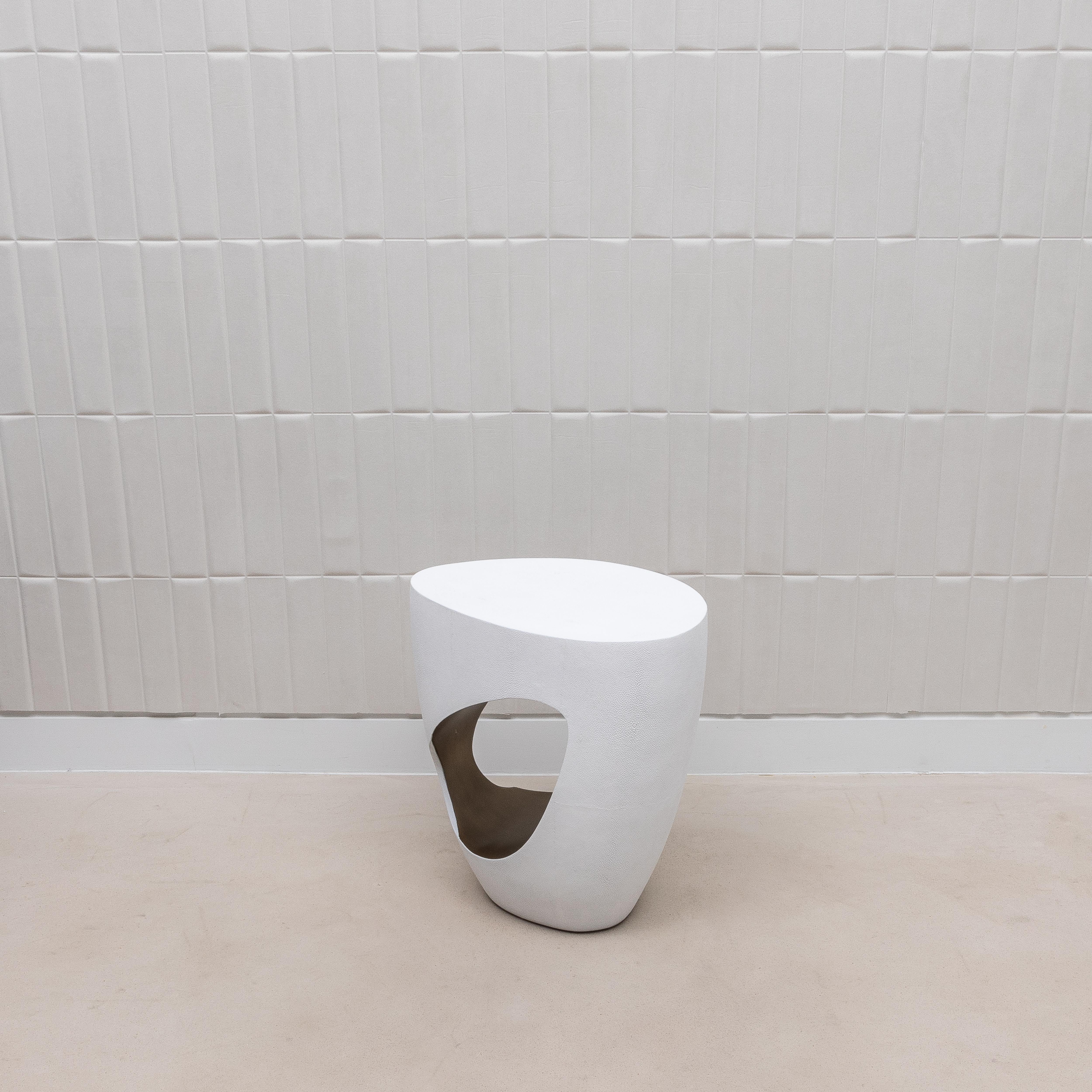 Le tabouret Eclipse de R&Y Augousti est une fusion frappante d'art et de fonctionnalité, enveloppé dans un luxueux galuchat blanc et rehaussé d'un intérieur en laiton patiné de bronze. Le design audacieux et sculptural du tabouret se caractérise par