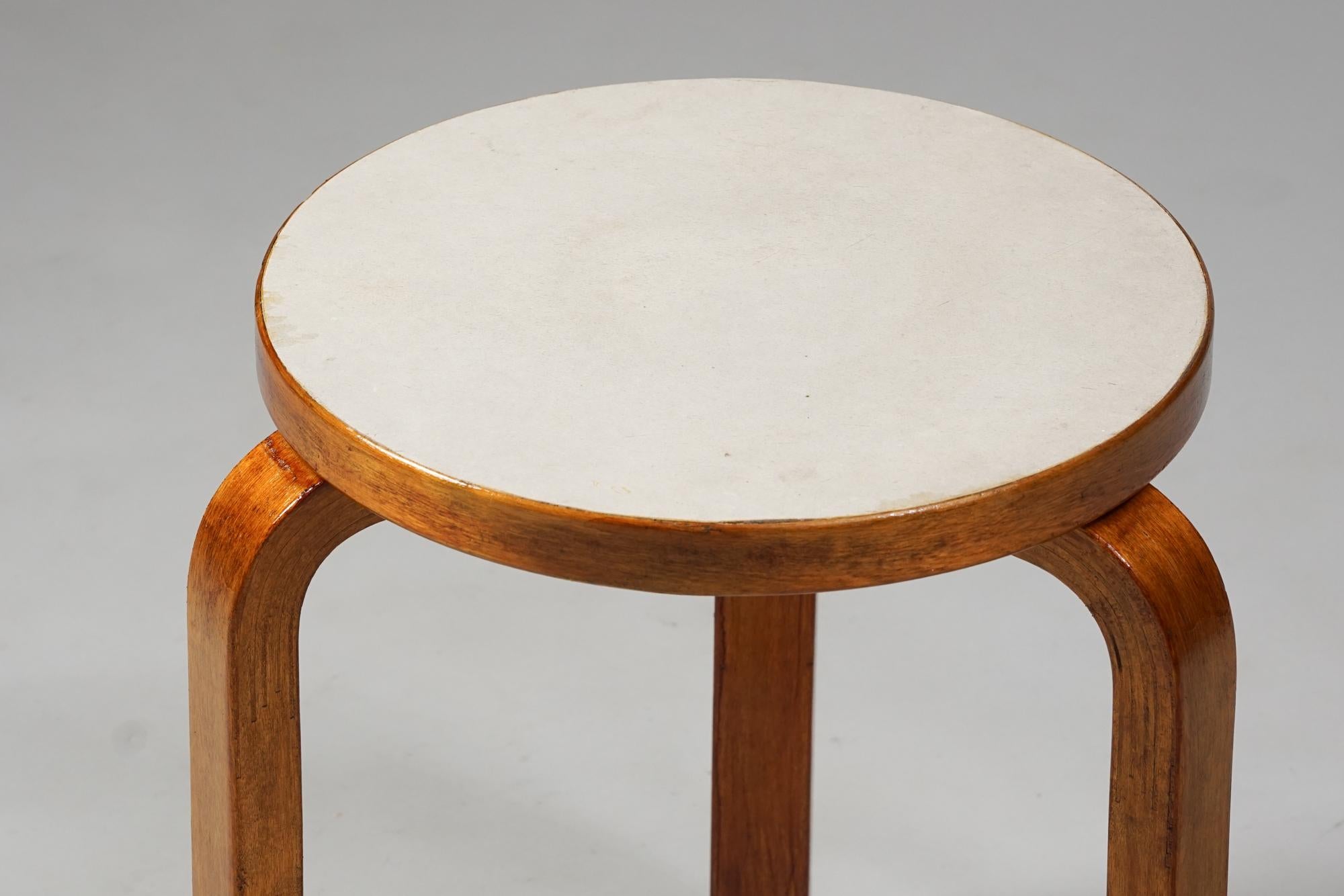 Stool model 60 by Alvar Aalto for Artek from the 1950s. Lacquered birch and linoleum top. Good vintage condition, rich patina and wear consistent with age and use. Iconic Alvar Aalto design. 
