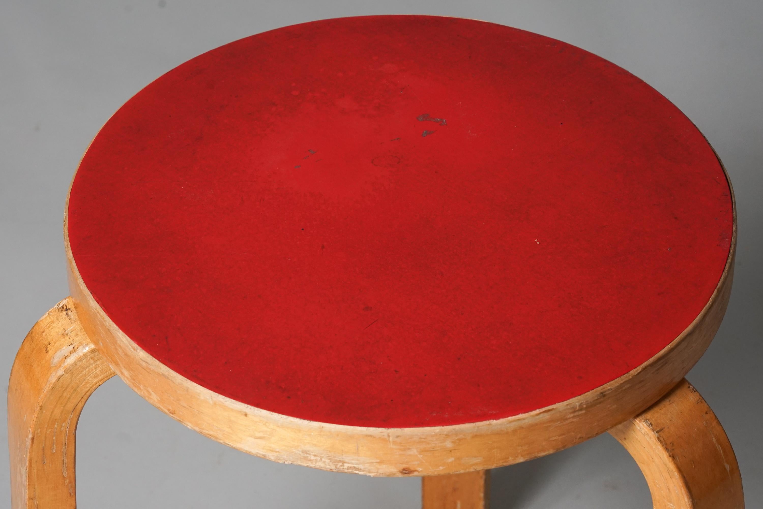Hocker Modell 60, entworfen von Alvar Aalto, hergestellt von Oy Huonekalu- ja Rakennustyötehdas Ab, 1950er Jahre. Birke mit rotem Linoleumsitz. Guter Vintage-Zustand, Patina und Abnutzung im Einklang mit Alter und Gebrauch. 

Alvar Aalto (1898-1976)