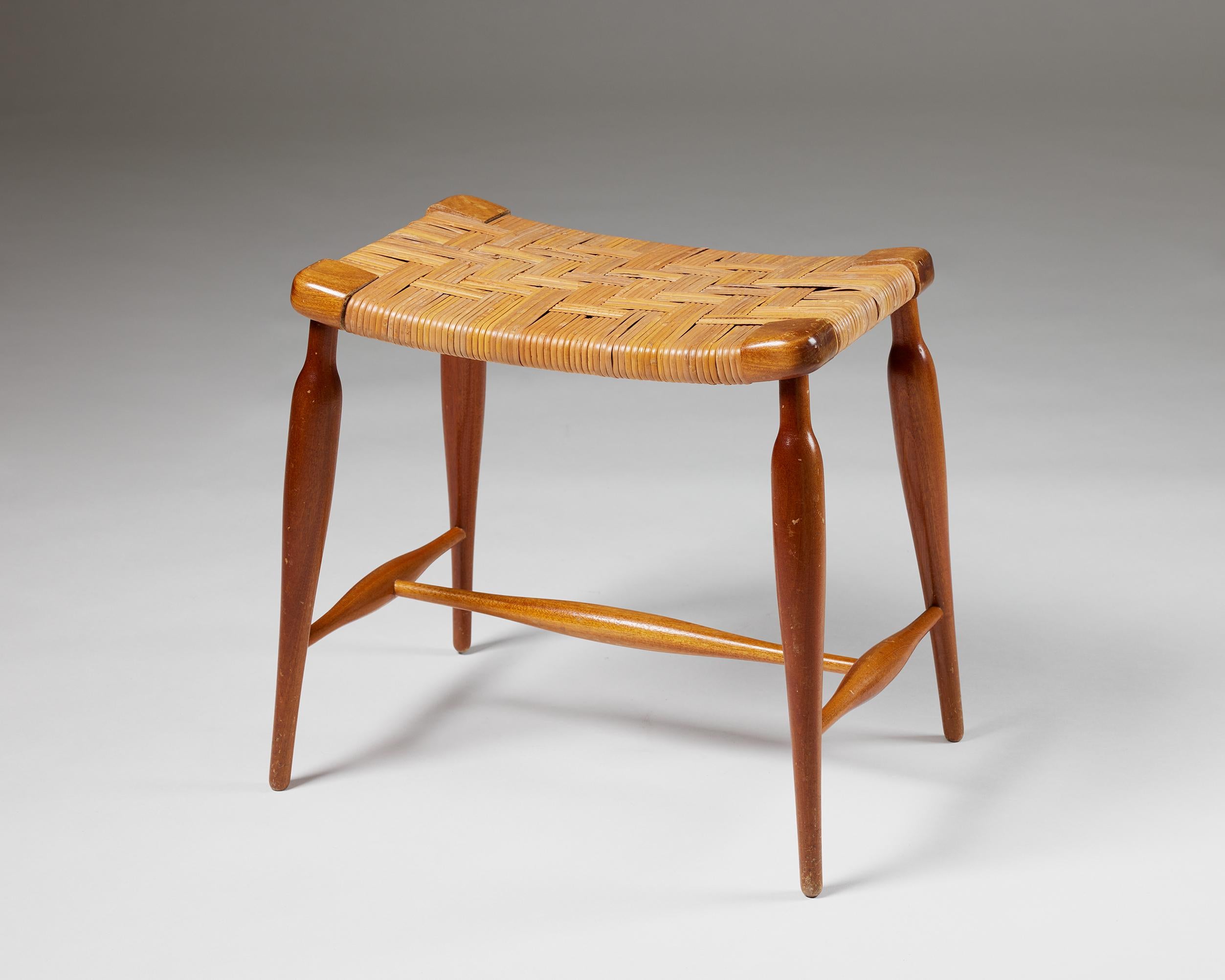 Stool model 927 designed by Josef Frank for Svenskt Tenn,
Sweden, 1950s.

Mahogany and rattan.

Measures: 
H: 43 cm
W: 43 cm
D: 28 cm

Josef Frank was a true European, he was also a pioneer of what would become classic 20th century Swedish design