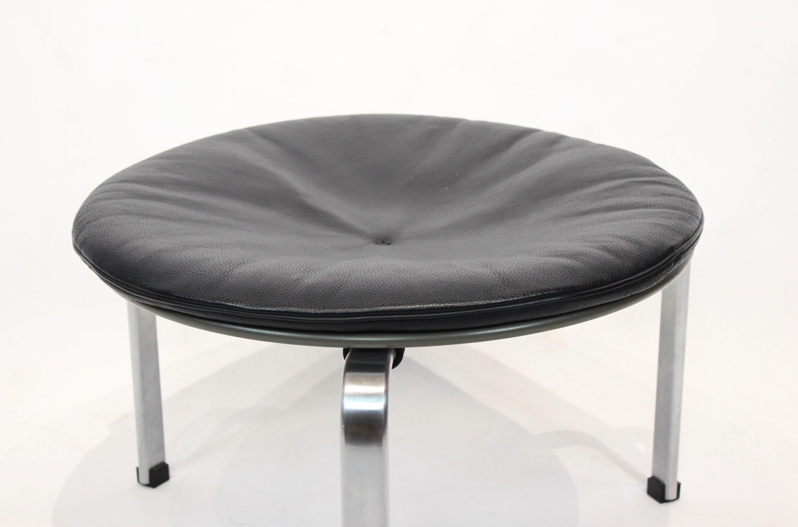 Stool, model PK33, with seat of black leather and frame of matt chrome spring steel, designed by Poul Kjærholm and manufactured by Fritz Hansen in 2004. The stool is in great used condition.