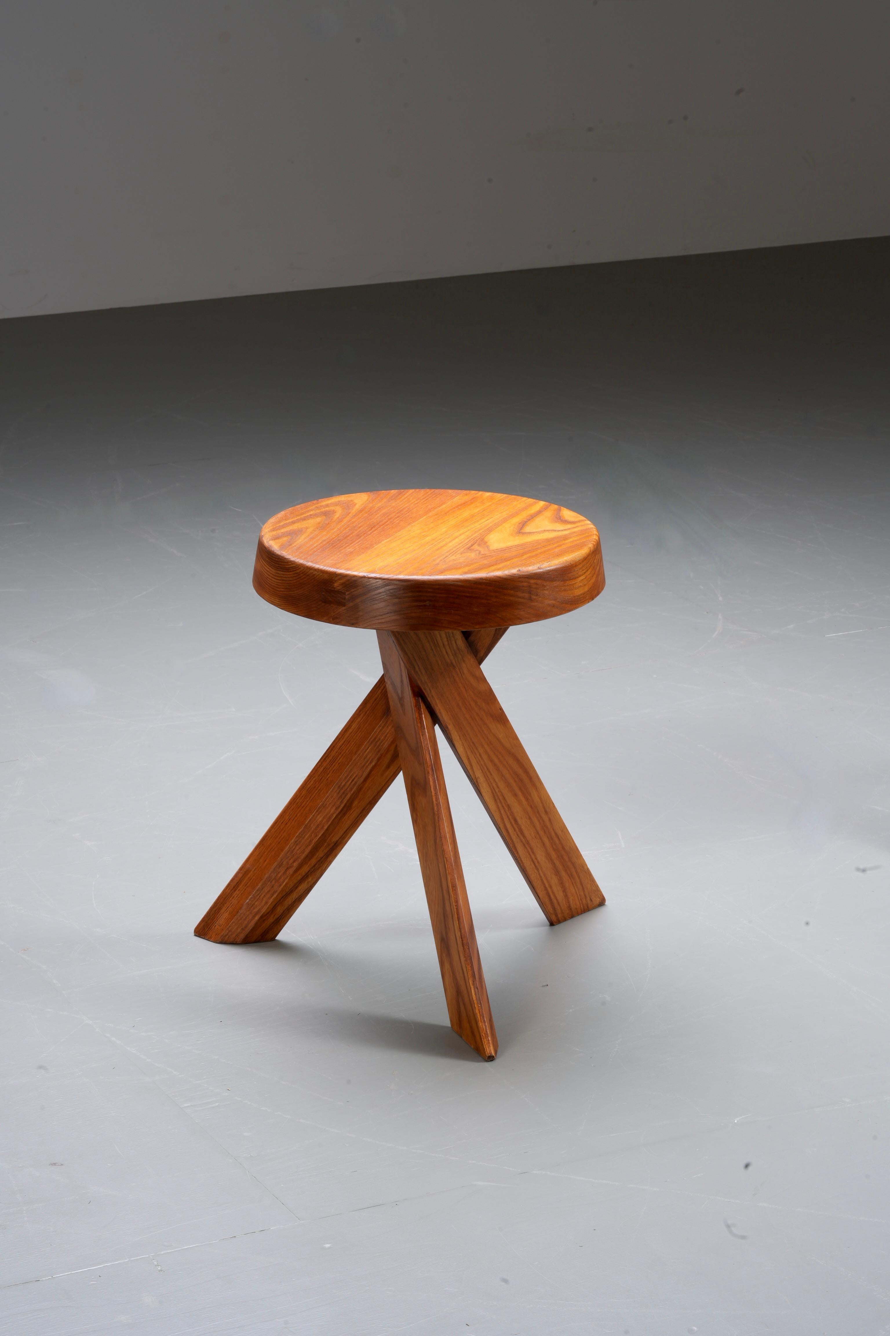 This stool is a striking example of Pierre Chapo's craftsmanship, featuring the S13a model from the 1970s, made in France. Crafted from solid elm, the stool shows a timeless elegance with its natural wood grain, highlighted by the smooth, rounded