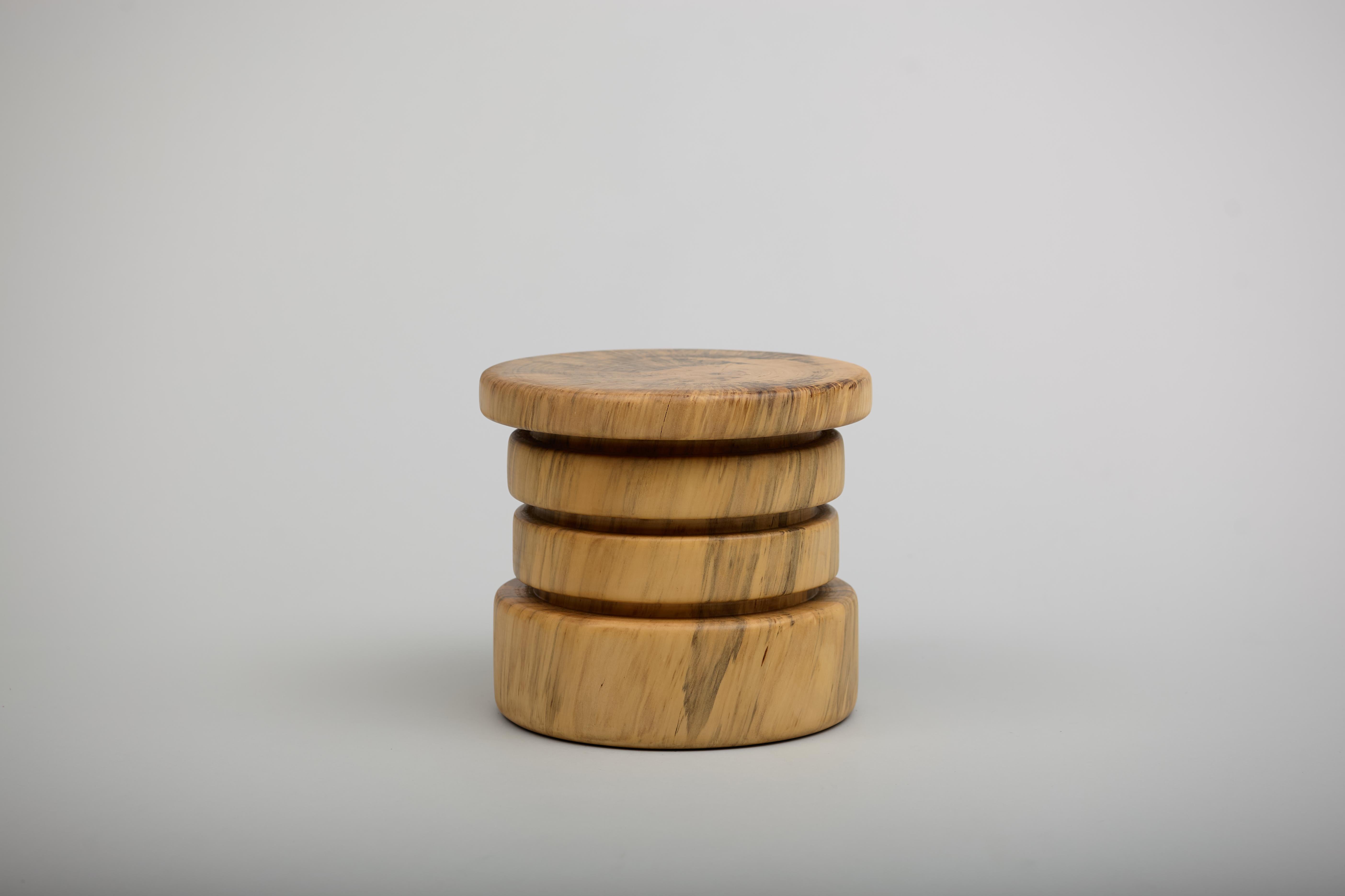 A solid wood stool turned on the lathe out of one piece of reclaimed Norfolk Island Pine. It can be used for a low seat, side table, or as a pedestal. It stands at 10.5 inches tall x 11.75 inches in diameter and weighs roughly 10 pounds. Features