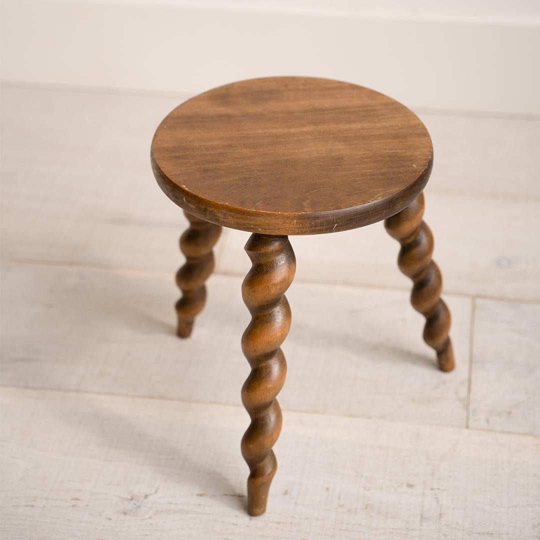 Este taburete de madera de patas retorcidas muestra una artesanía única con sus patas talladas en espiral y su asiento liso y redondeado, convirtiéndolo en un acento encantador.

