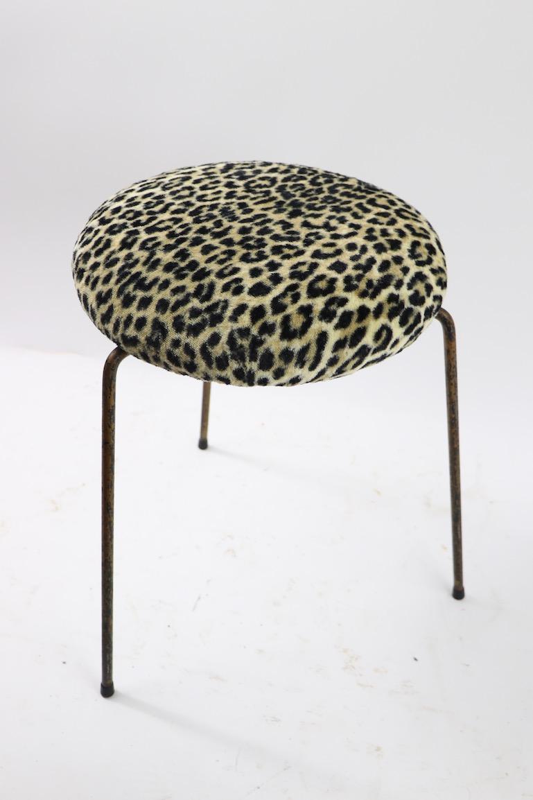 Nice midcentury three leg stool having a newly upholstered pad top in furry leopard fabric. The wrought iron legs show cosmetic wear to the paint finish, normal and consistent with age. Diameter of pad seat 15 inches Usable as a stool, footstool,