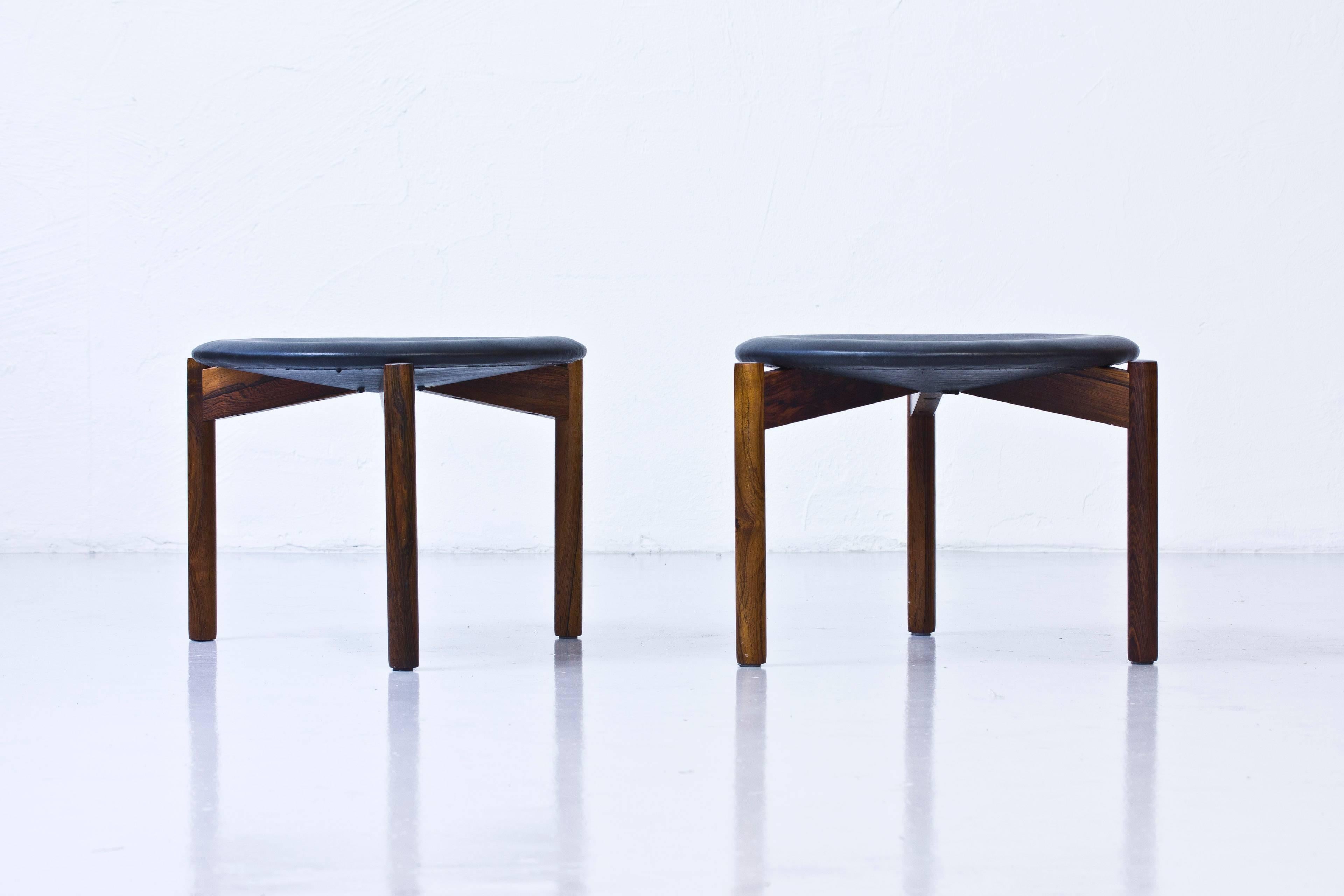 Very rare pair of stools deigned by Uno and Osten Kristiansson. Produced by Luxus in Vittsjo, Sweden during the 1960s. Made from solid rosewood. Recently reupholstered with new padding and black leather. Excellent condition with very few signs of