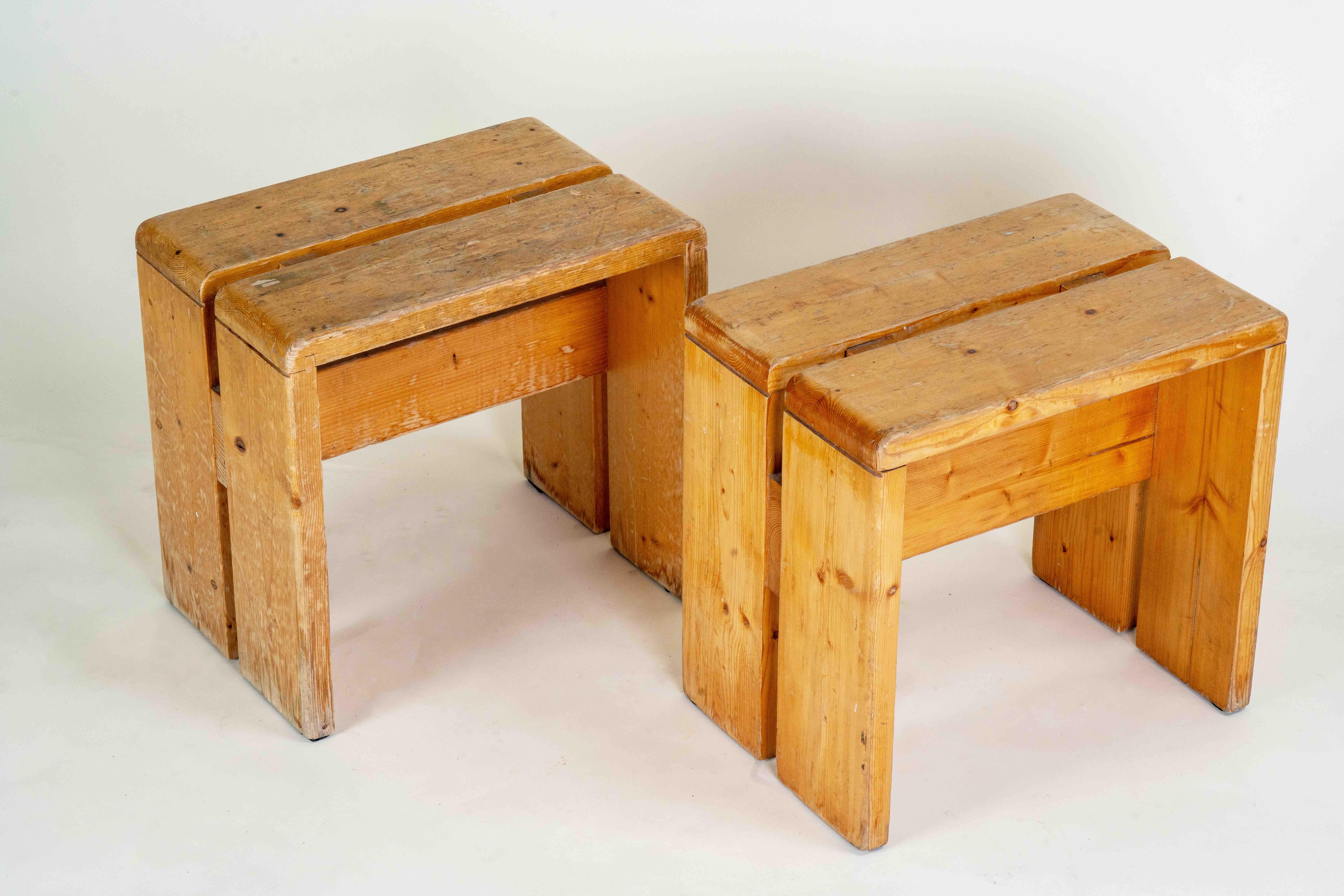Taburete clásico de pino diseñado por Charlotte Perriand para la estación de esquí de Les Arcs (Francia). Grandes líneas y simplicidad comunes con los diseños de Perriand. Travesaños de madera bajo el asiento y dos tacos de pino en el asiento de