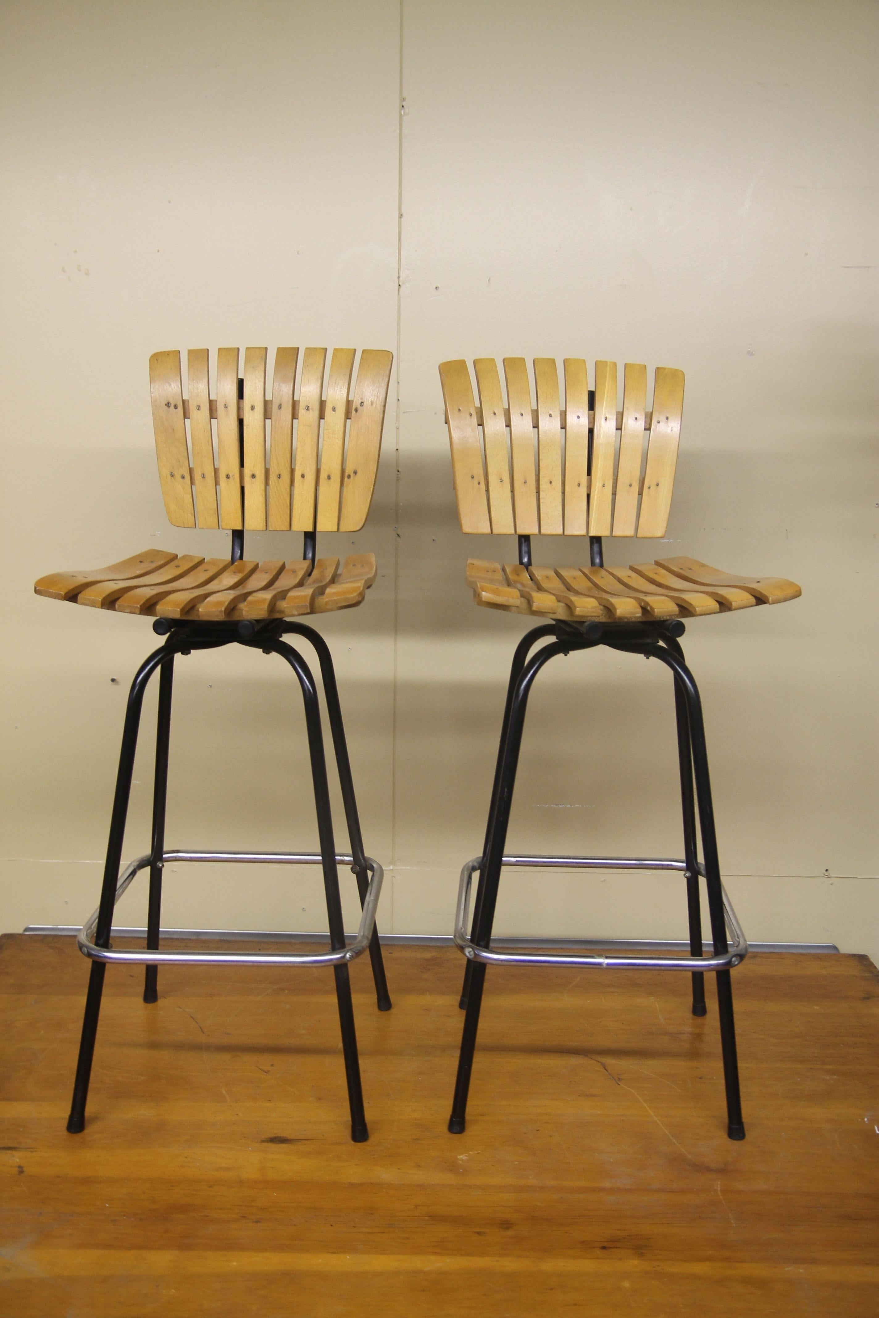 Vintage metal and wood stools in the manner of Arthur Umanoff. These swivel stools are in nice vintage conditon.