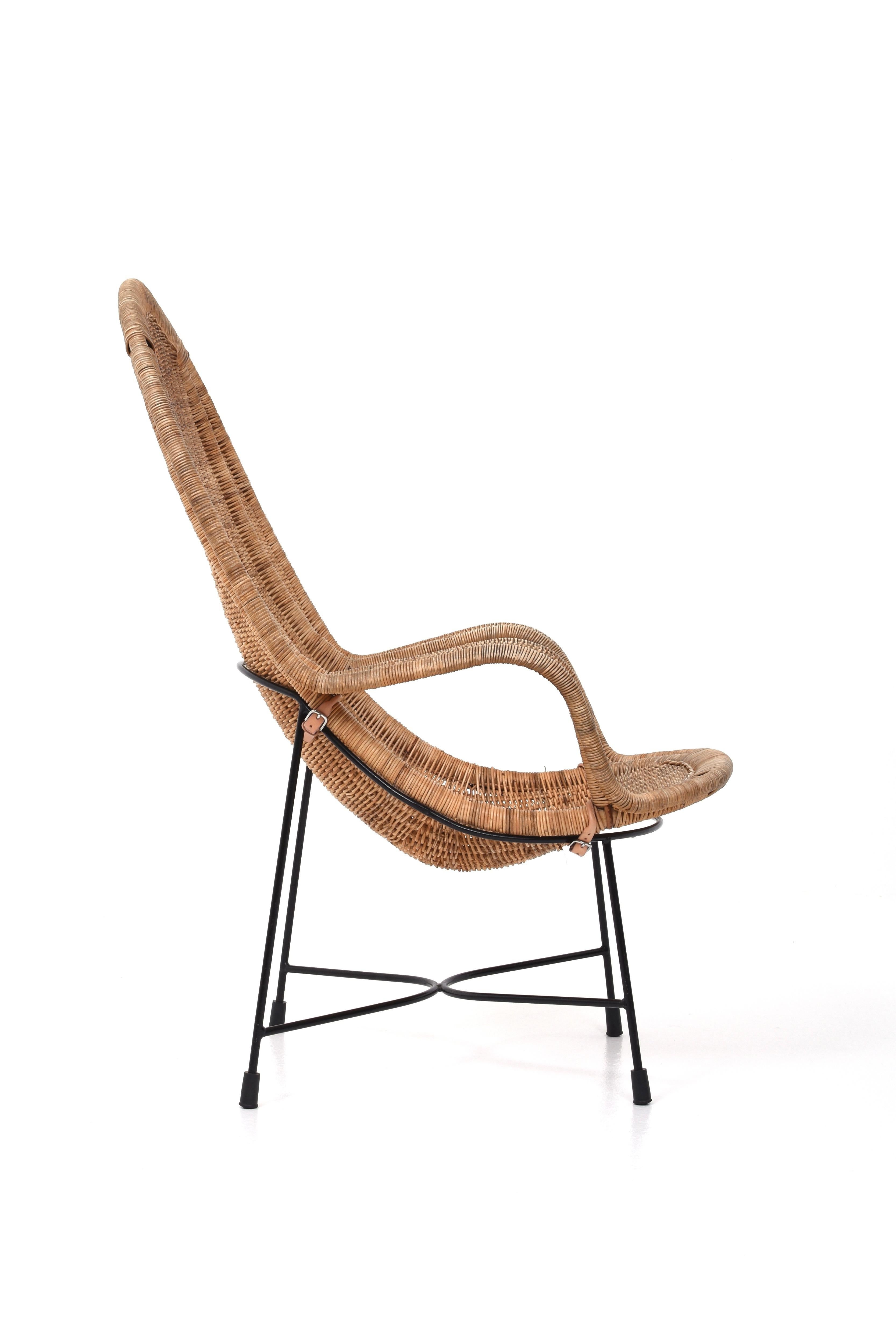 This is an unusual model called Stora Kraal and is designed by Kerstin Hörlin-Holmquist for Nordiska Kompaniet.

The armchair is woven in rattan with a black metal base held together by small leather straps.

The armchair has been given new straps,