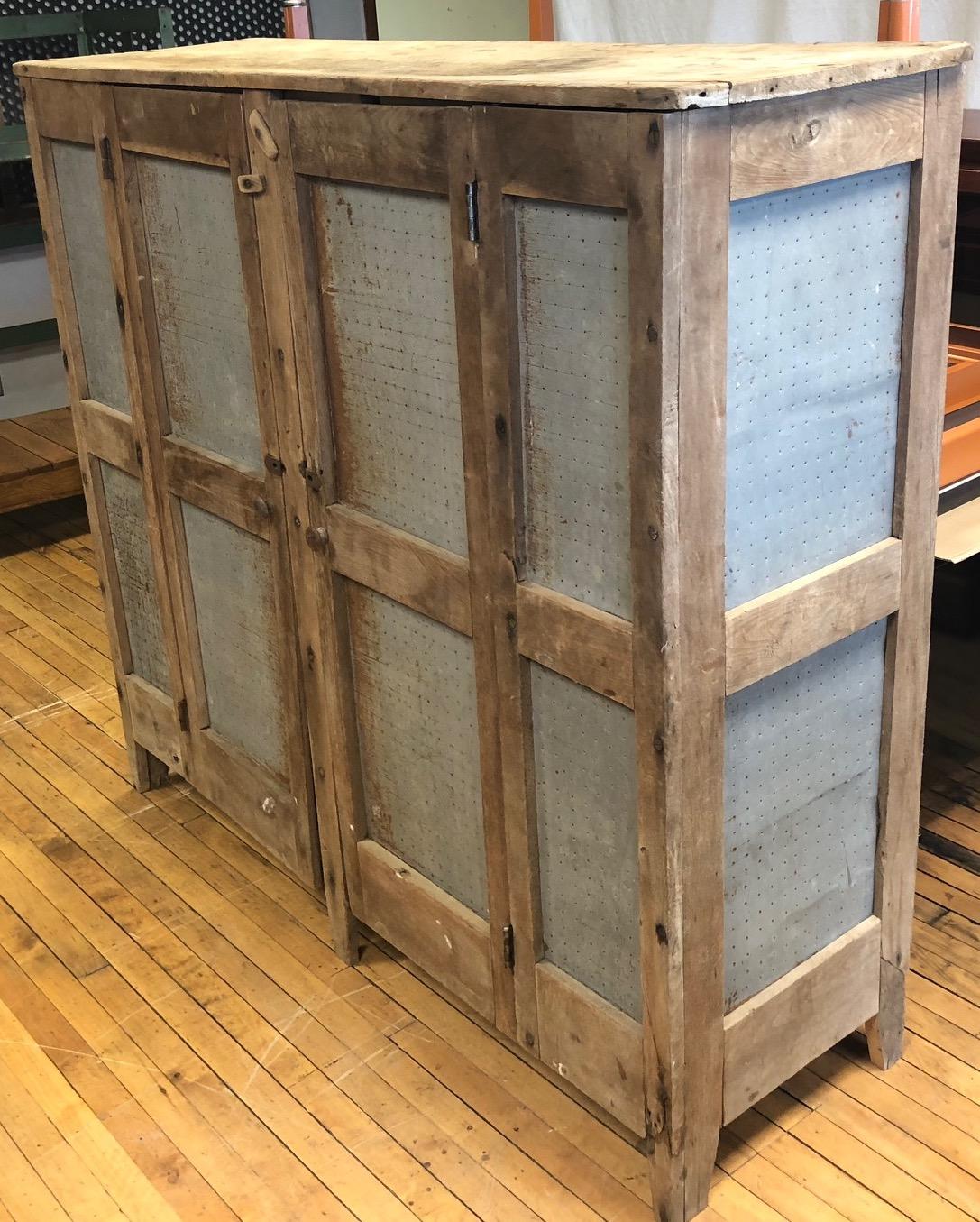 Storage cabinet, meat safe of unvarnished walnut used by the Amish to store smoked and preserved meat. With original square nail hardware, circa late 1800s. The Amish did not have electricity or use refrigerated ice box/freezers. They would smoke